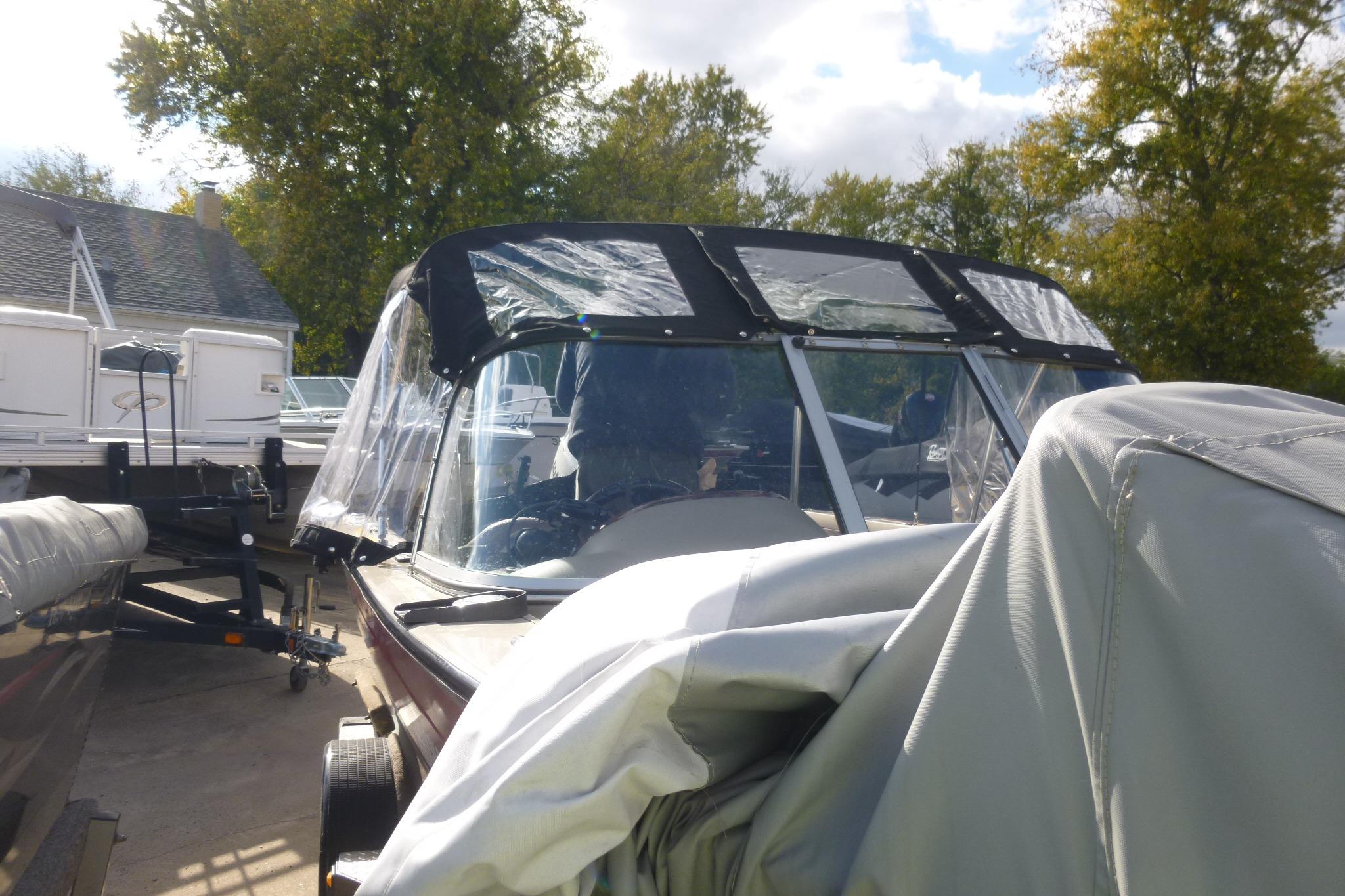 2007 Triton DV 176 Mag boat with protective cover, parked outdoors.