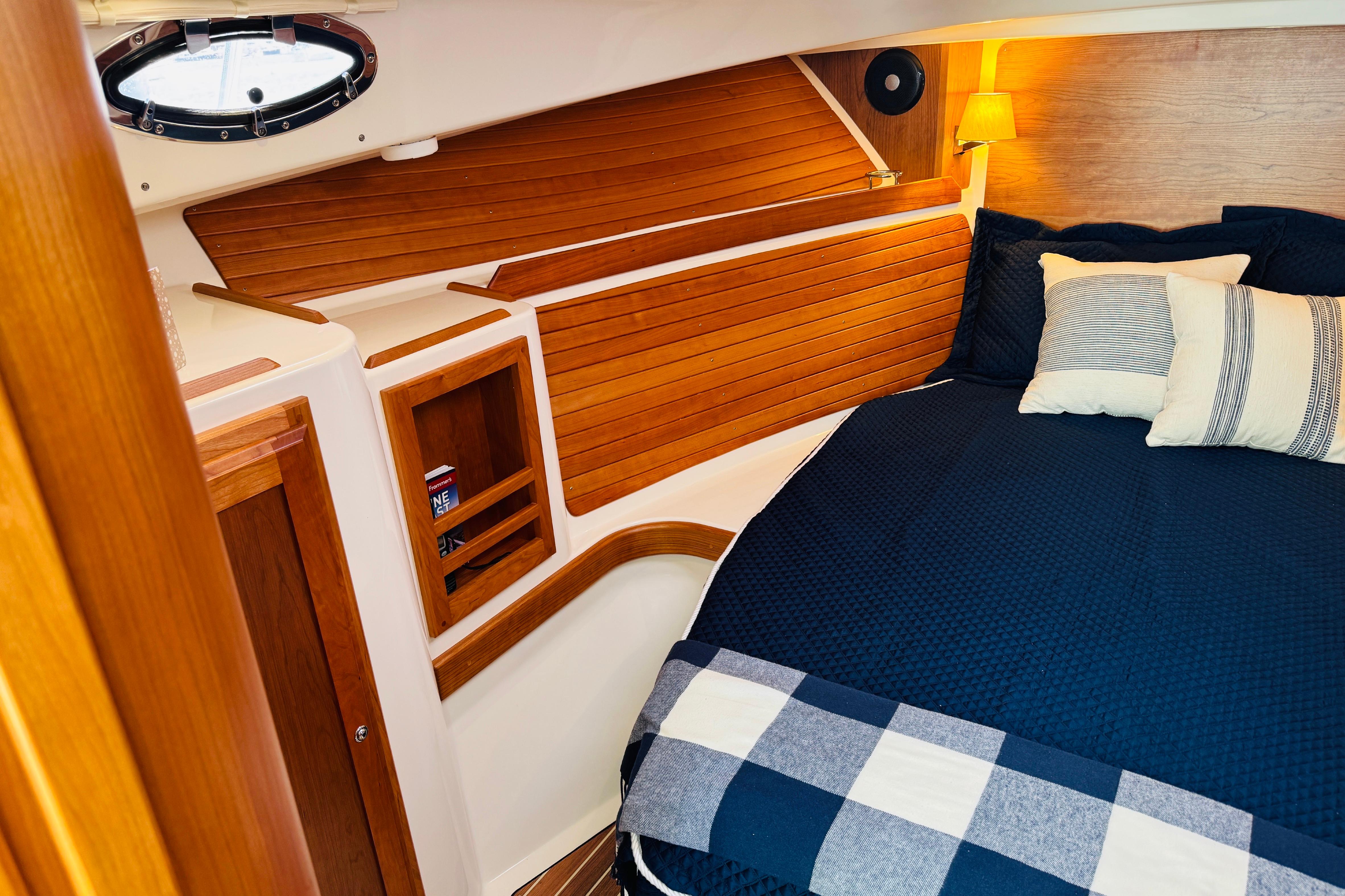 Cozy cabin interior of 2025 Back Cove 34O with wood paneling and navy bedding.
