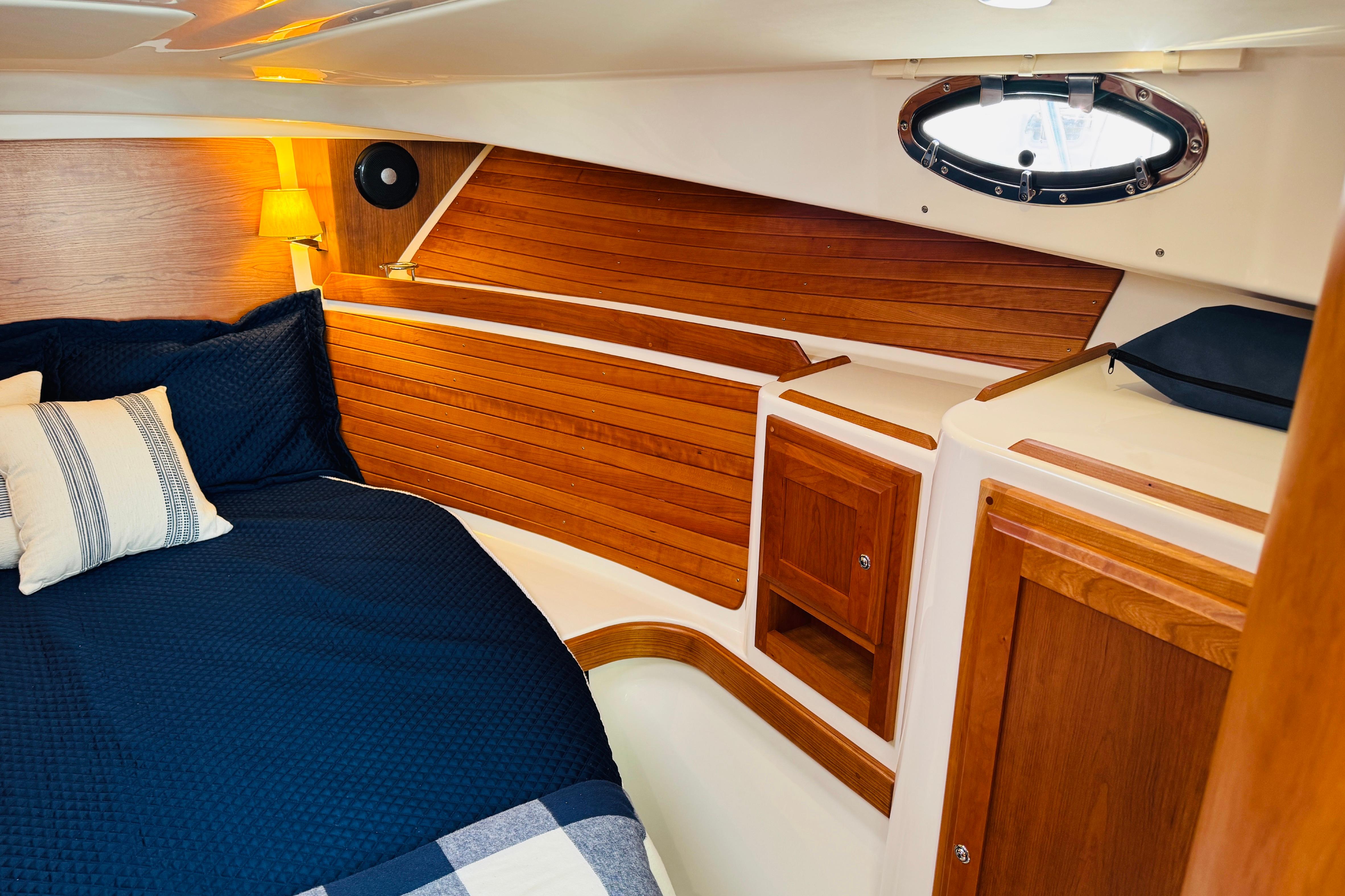 Luxurious cabin interior of 2025 Back Cove 34O with wood paneling and cozy bedding.