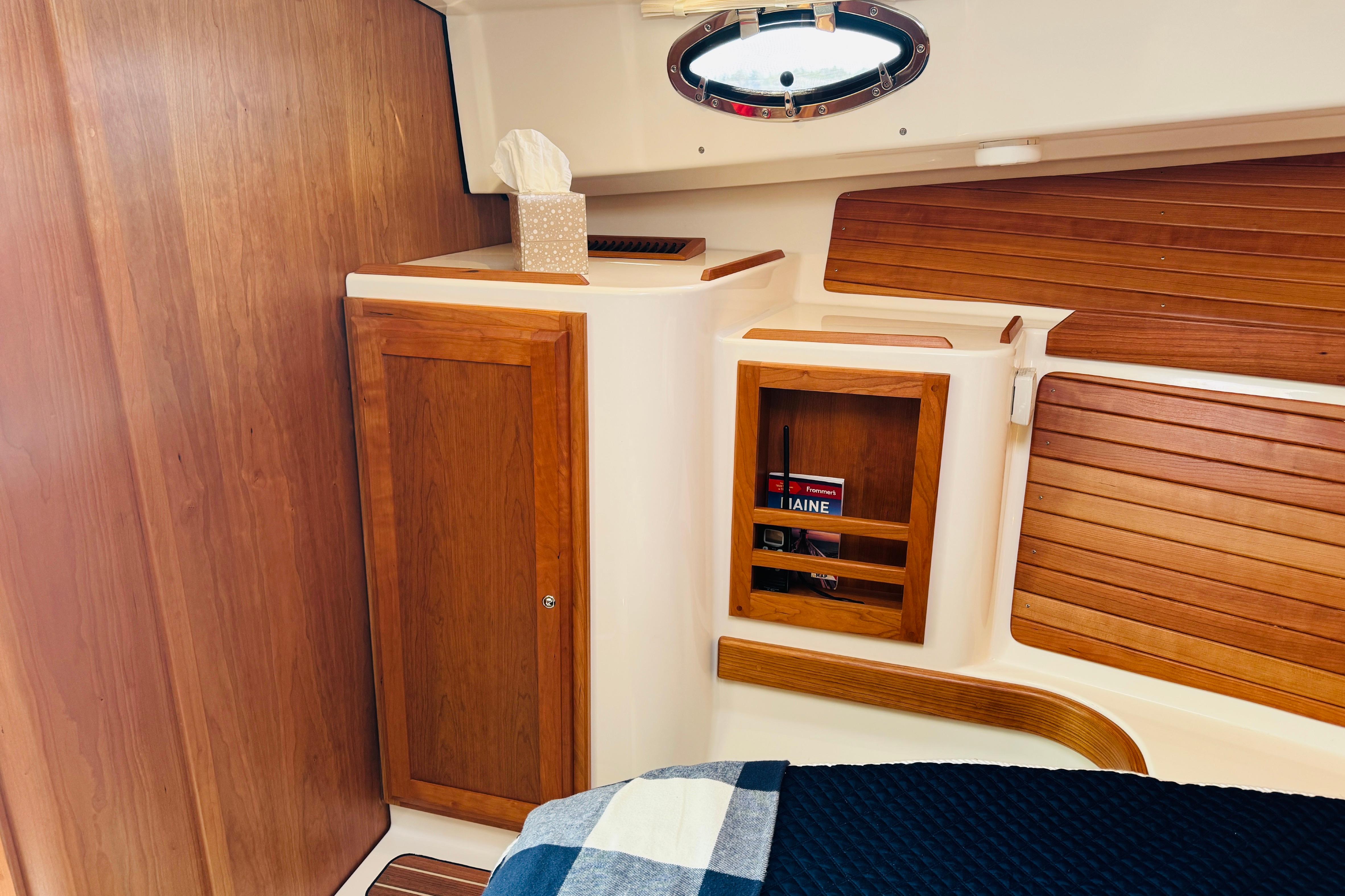 2025 Back Cove 34O cabin interior with wooden cabinetry and nautical decor.