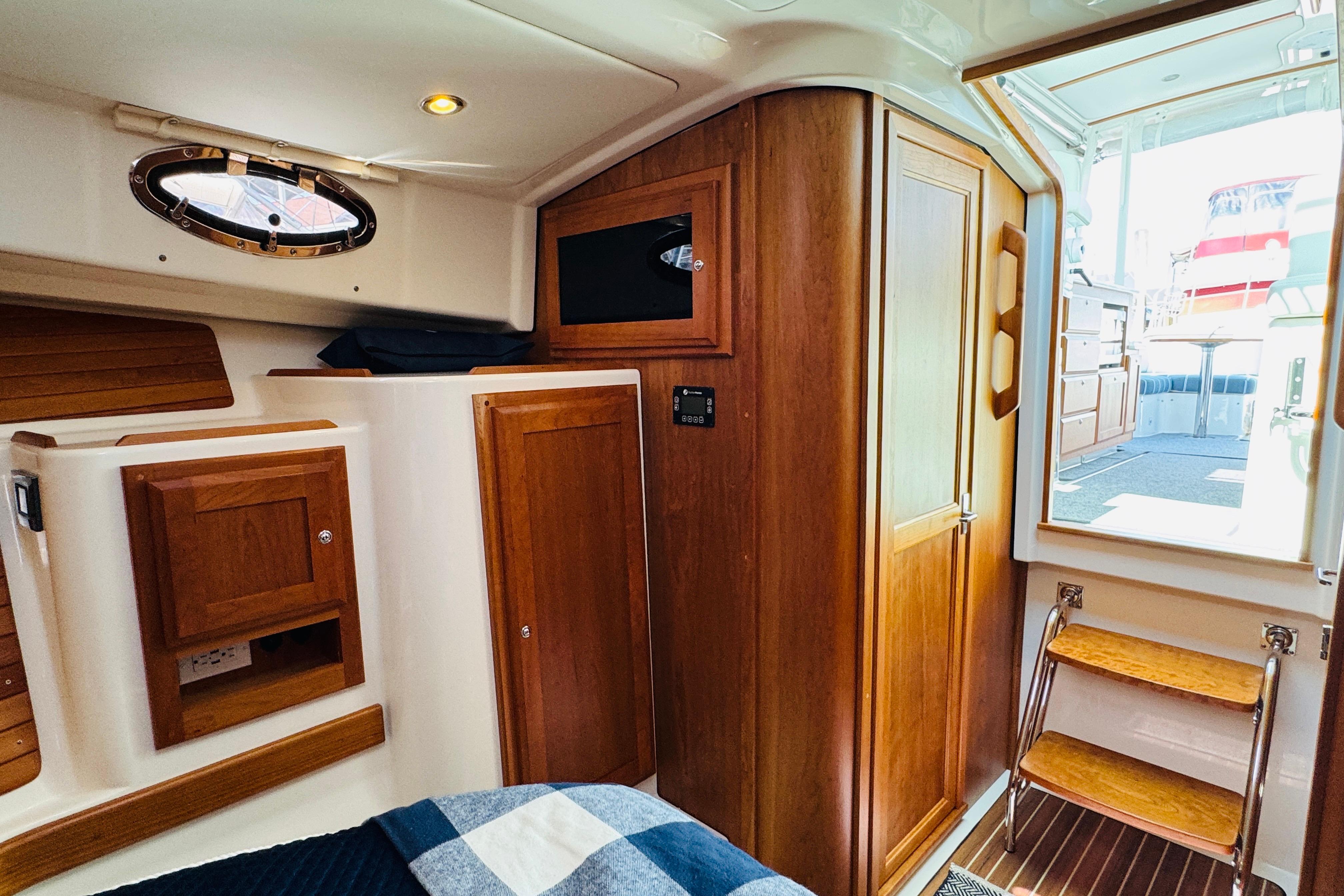 Interior of 2025 Back Cove 34O yacht, featuring wooden cabinetry and cozy design.