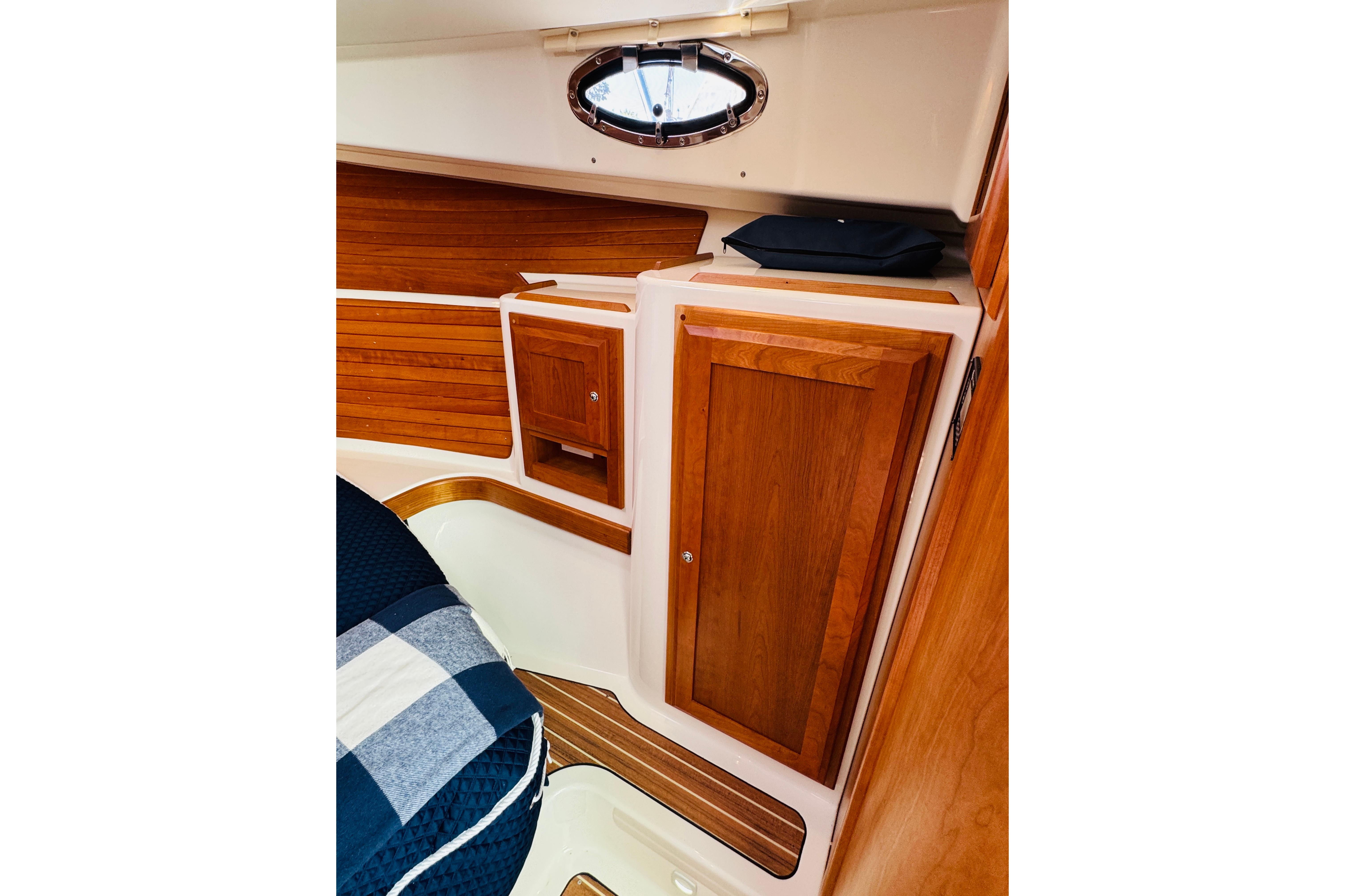 2025 Back Cove 34O cabin interior with wooden cabinetry and nautical decor.