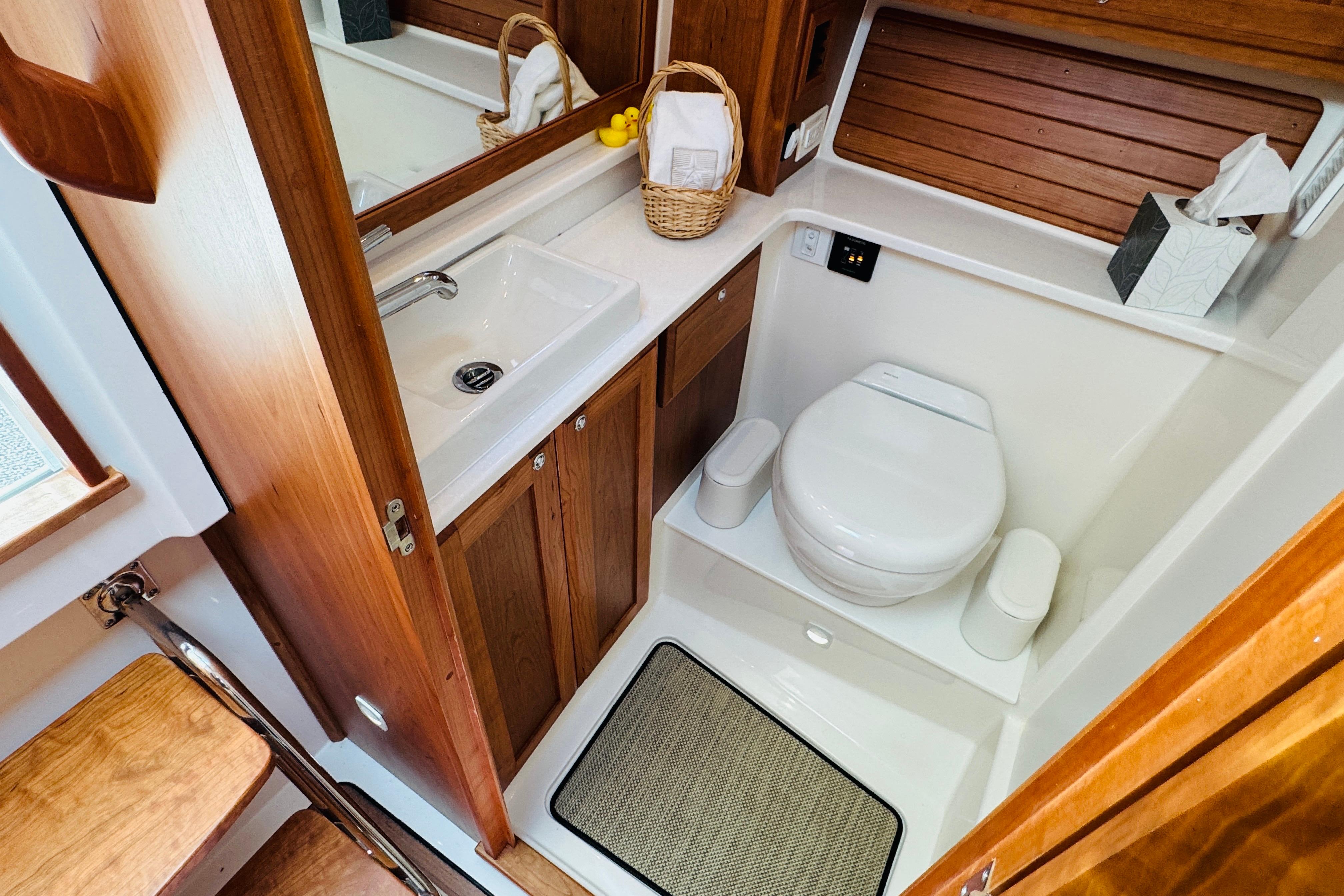 Bathroom interior of 2025 Back Cove 34O boat, featuring wooden cabinetry and modern fixtures.