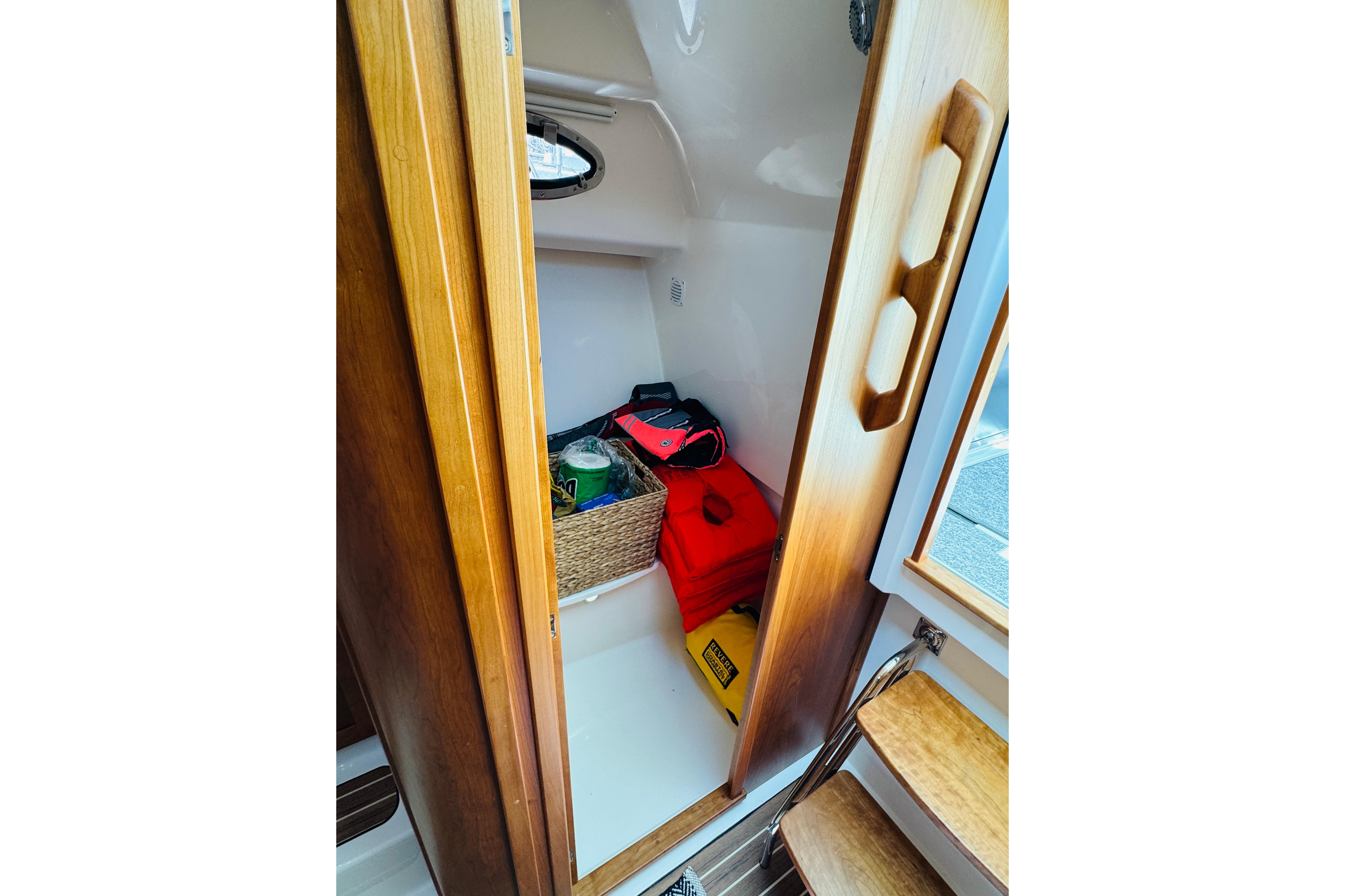 Storage compartment in 2025 Back Cove 34O boat with life jackets and supplies.