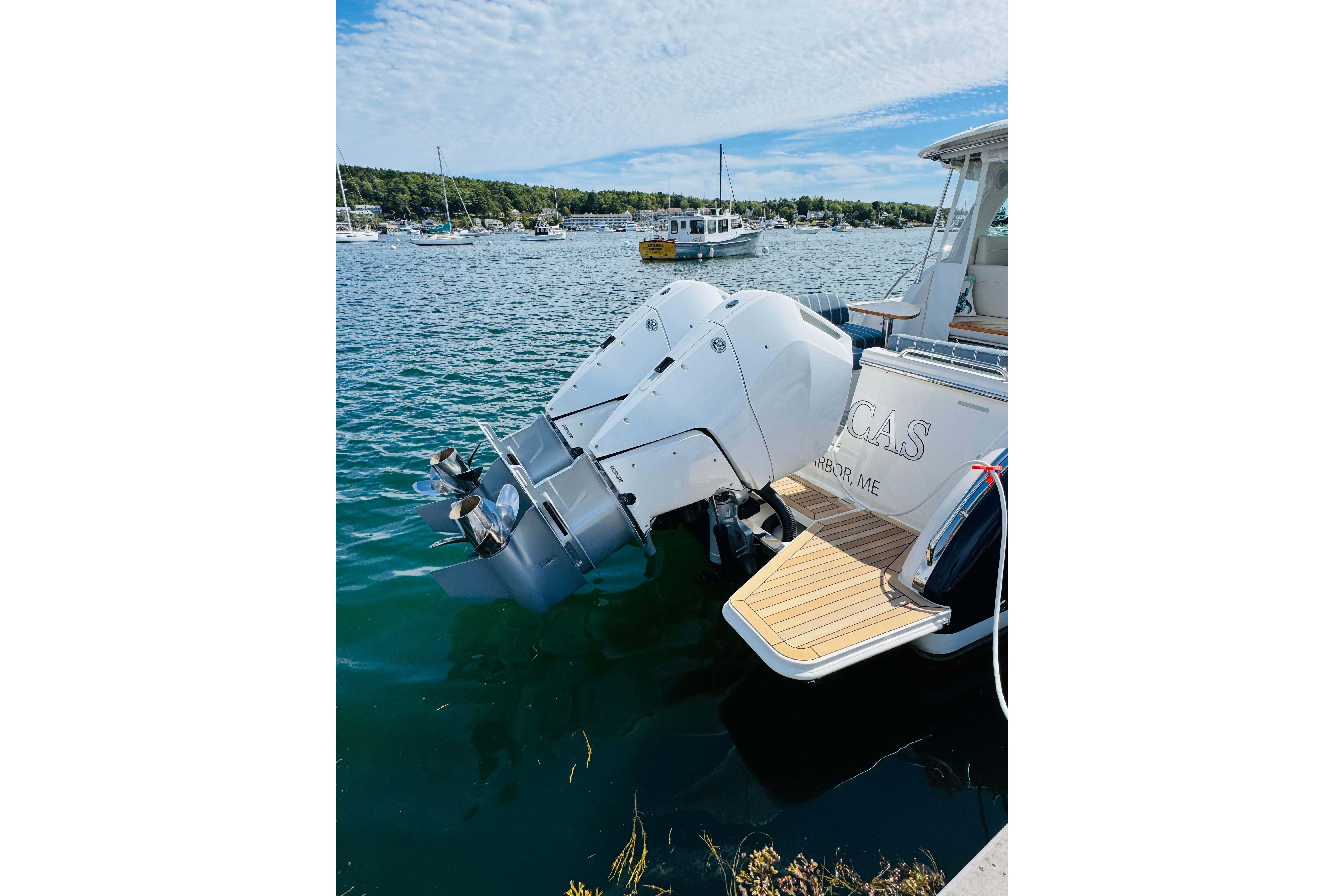 2025 Back Cove 34O boat with dual outboard engines docked in a scenic harbor.