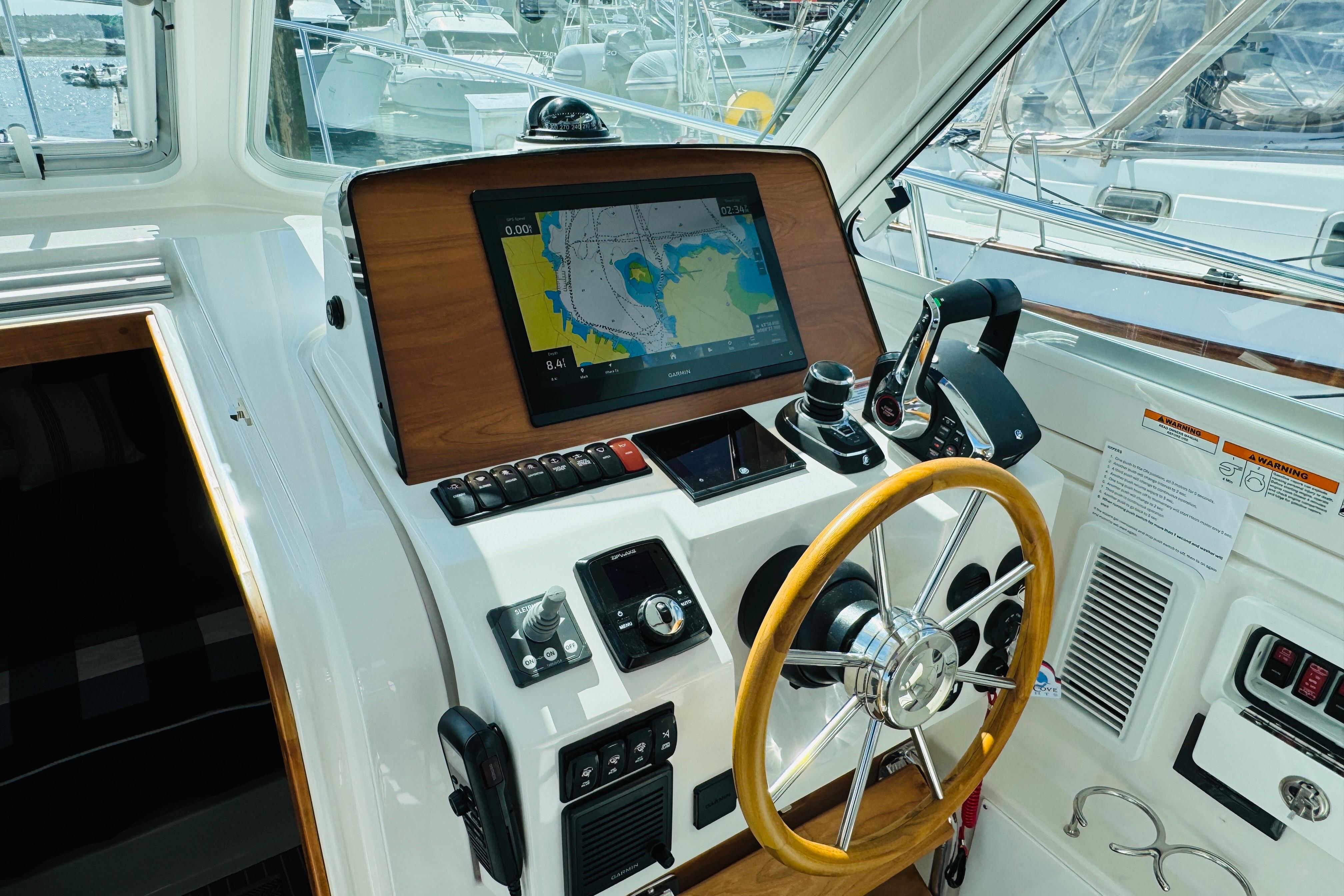 Helm of 2025 Back Cove 34O boat with navigation display and controls.