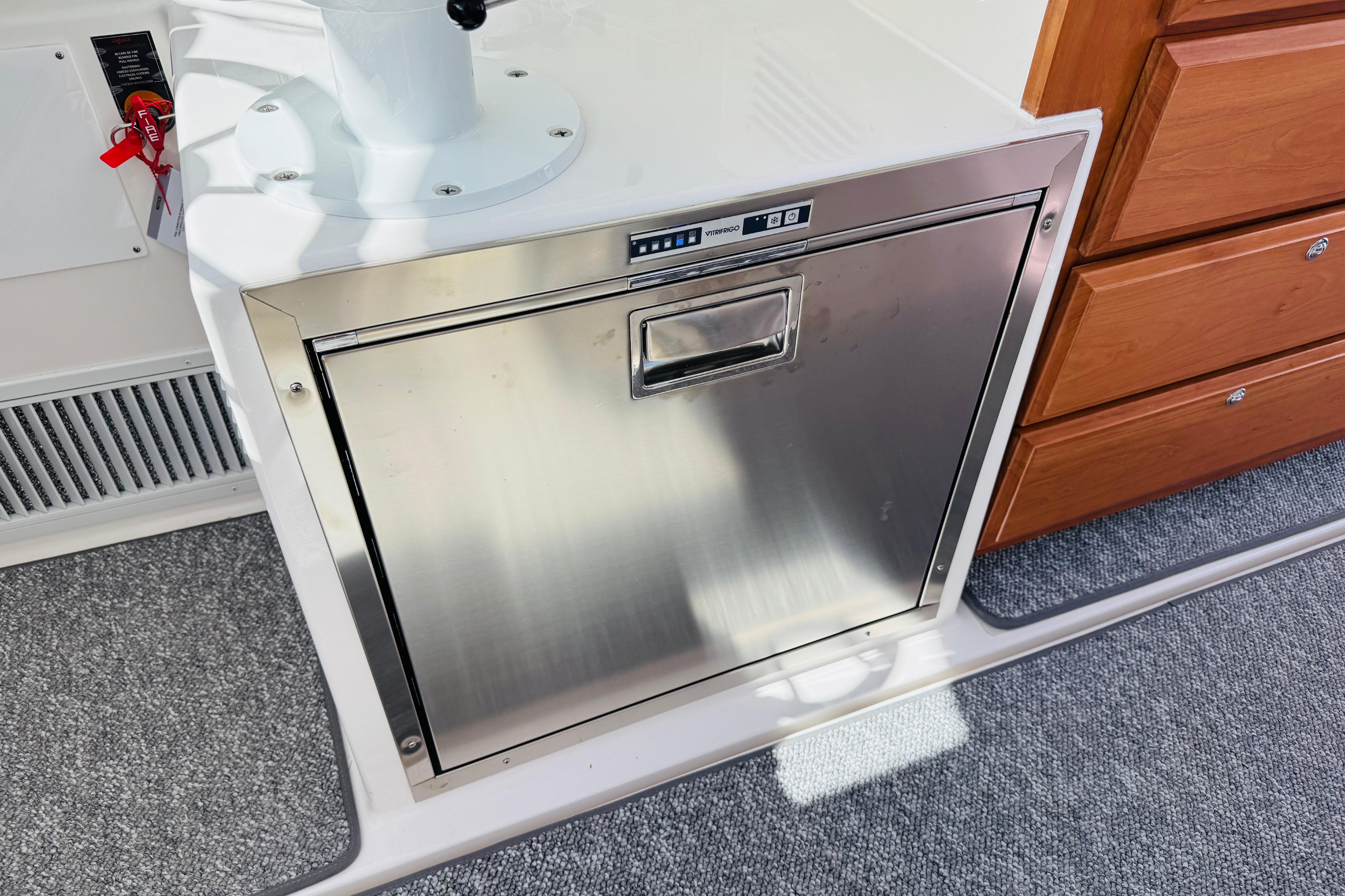 Stainless steel appliance on 2025 Back Cove 34O boat, next to wooden drawers.