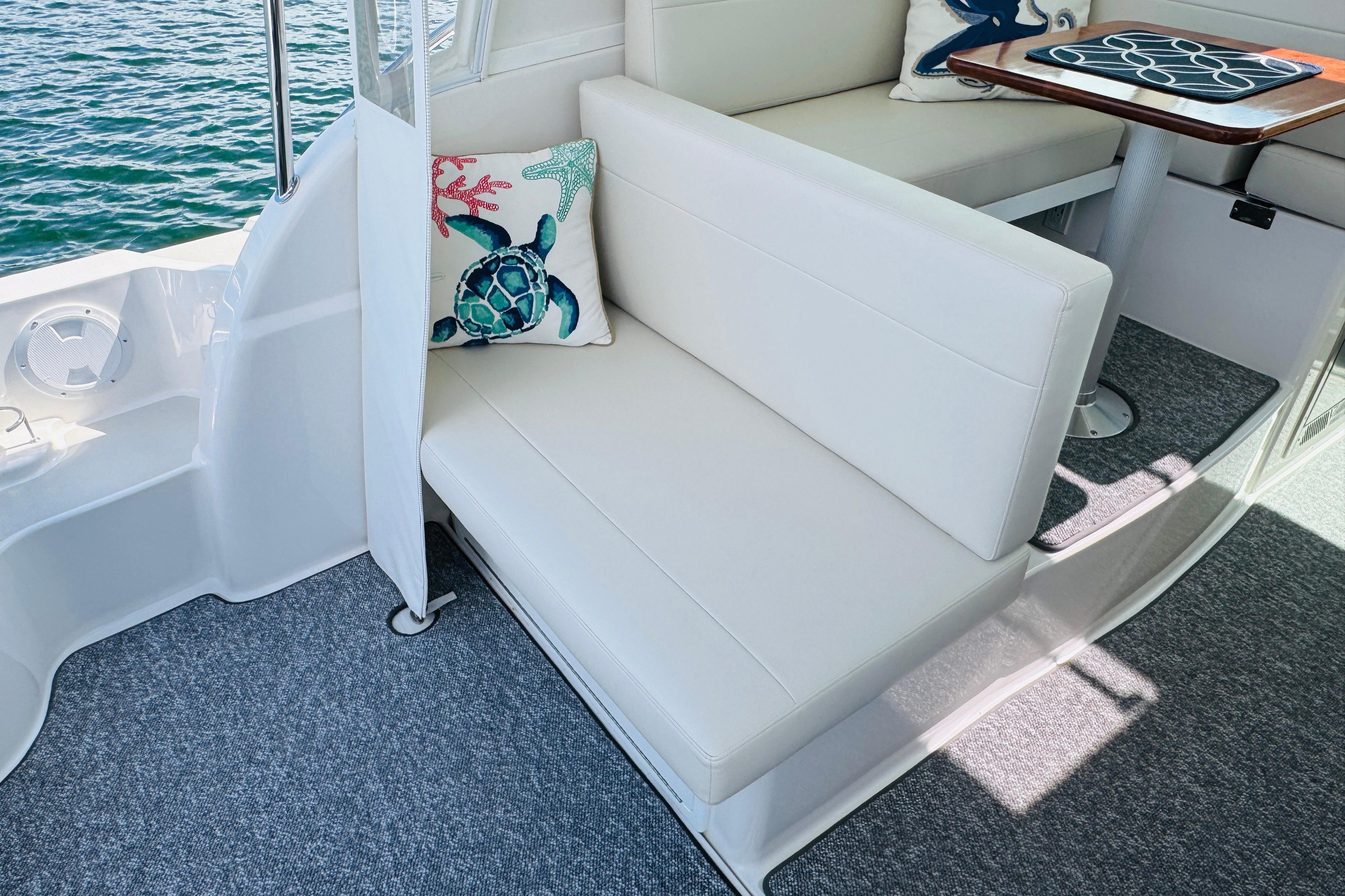 2025 Back Cove 34O boat interior with white seating and decorative pillows.