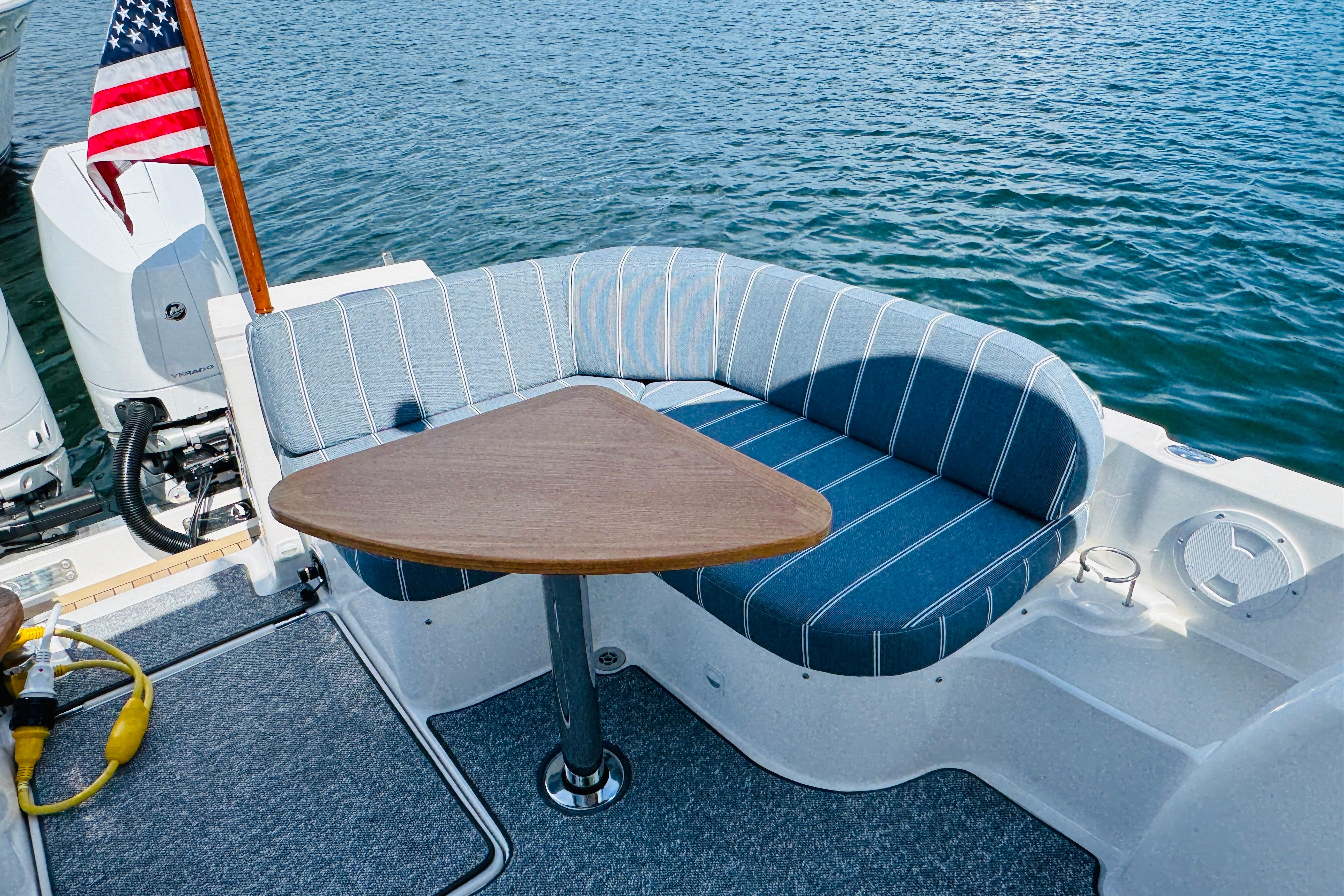 2025 Back Cove 34O boat with striped seating and triangular table on deck.