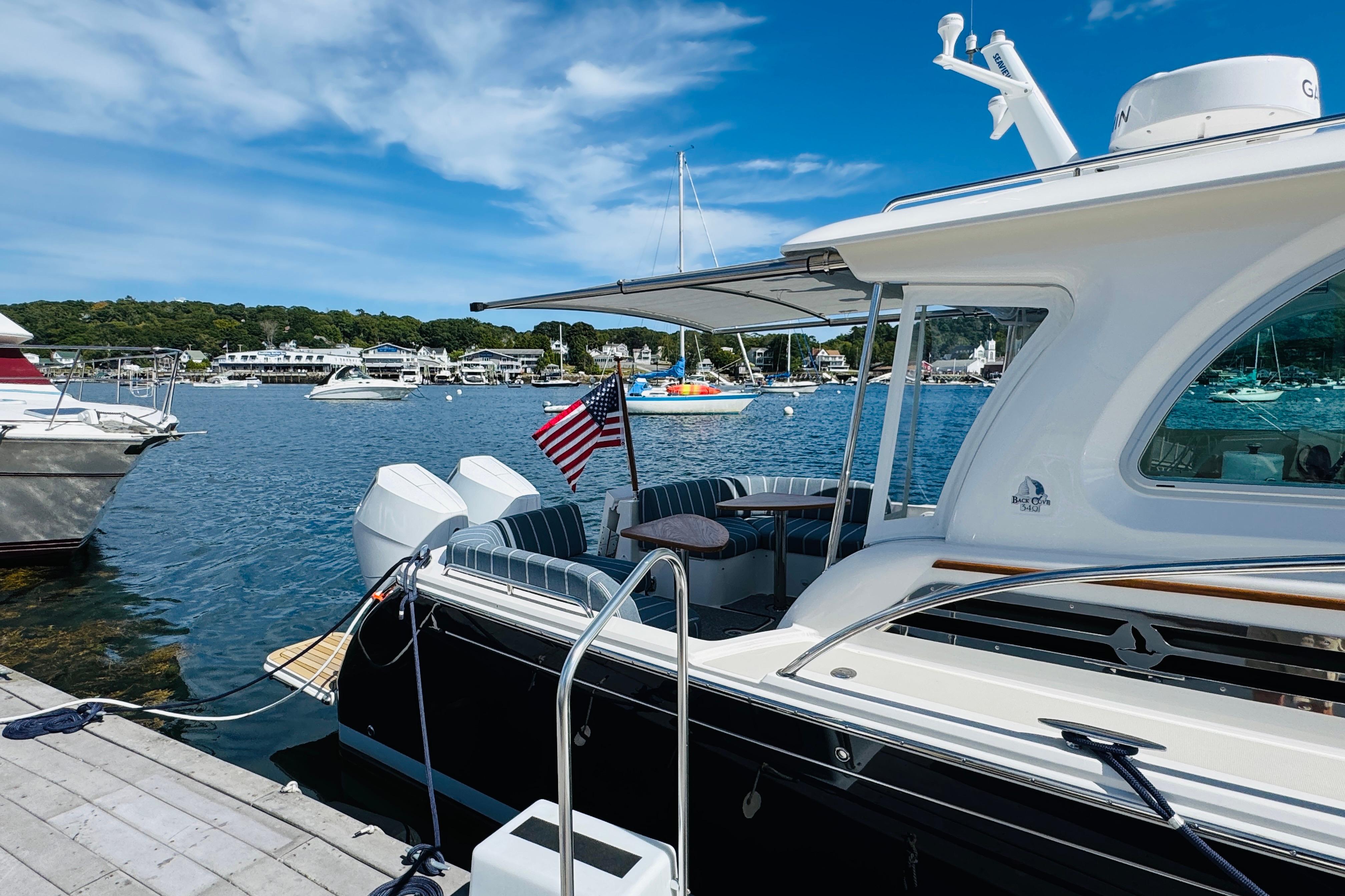 2025 Back Cove 34O yacht docked at marina, featuring sleek design and American flag.
