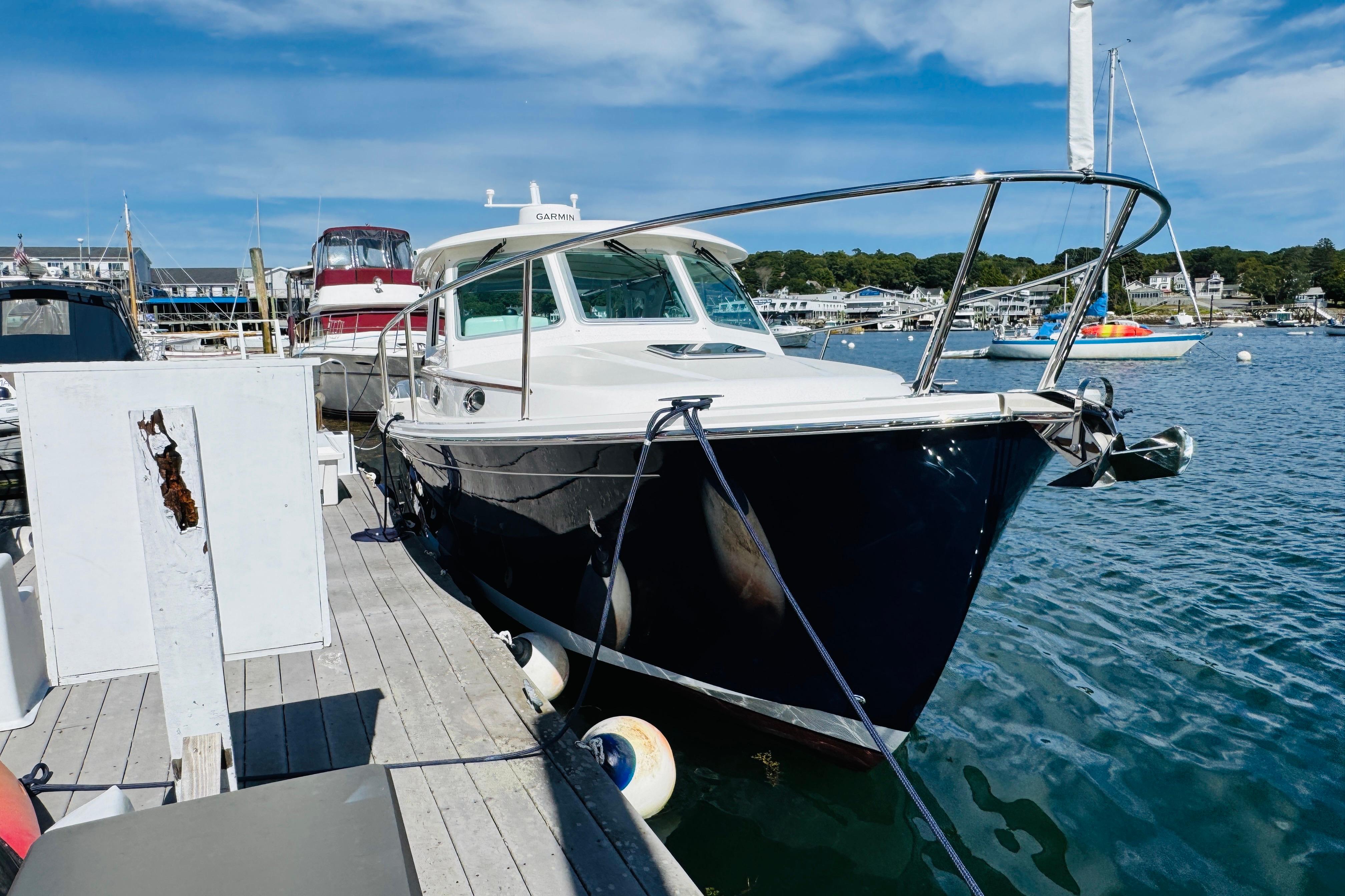 2025 Back Cove 34O yacht docked at marina under clear blue sky.