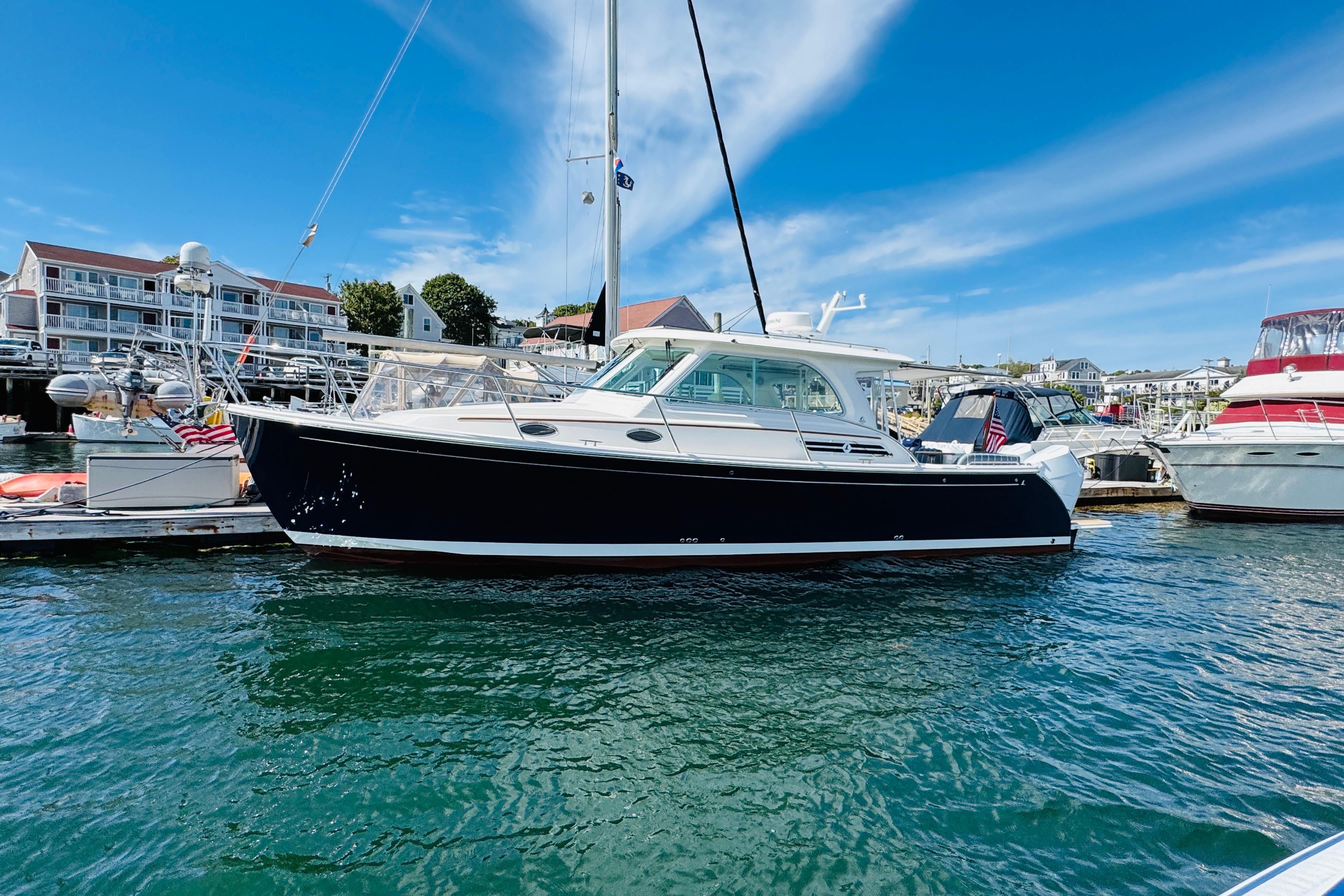 2025 Back Cove 34O yacht docked in a marina under a clear blue sky.