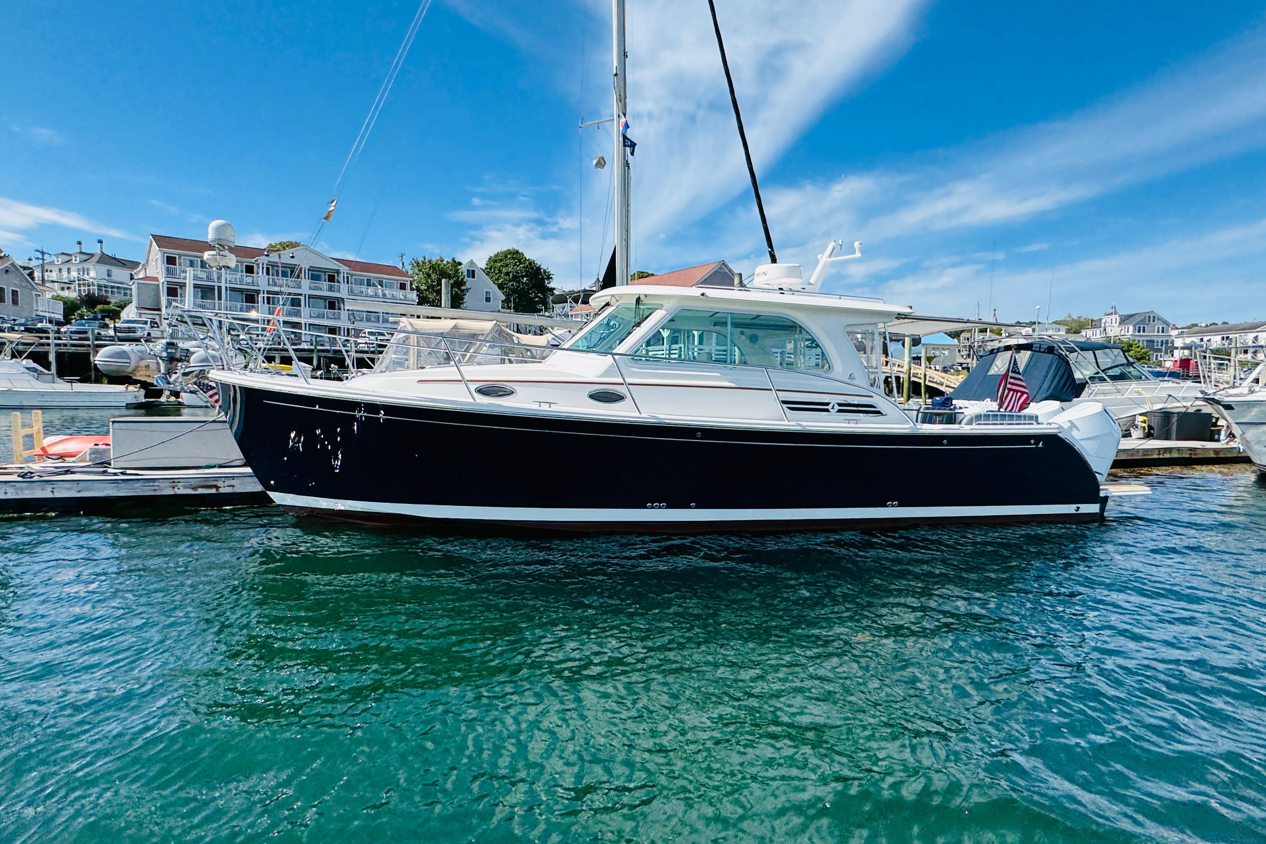 2025 Back Cove 34O yacht docked in a marina under a clear blue sky.