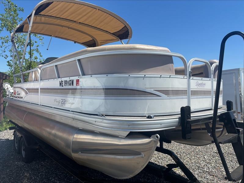 2015 Sun Tracker PARTY BARGE® 22 DLX pontoon boat on trailer, under clear blue sky.