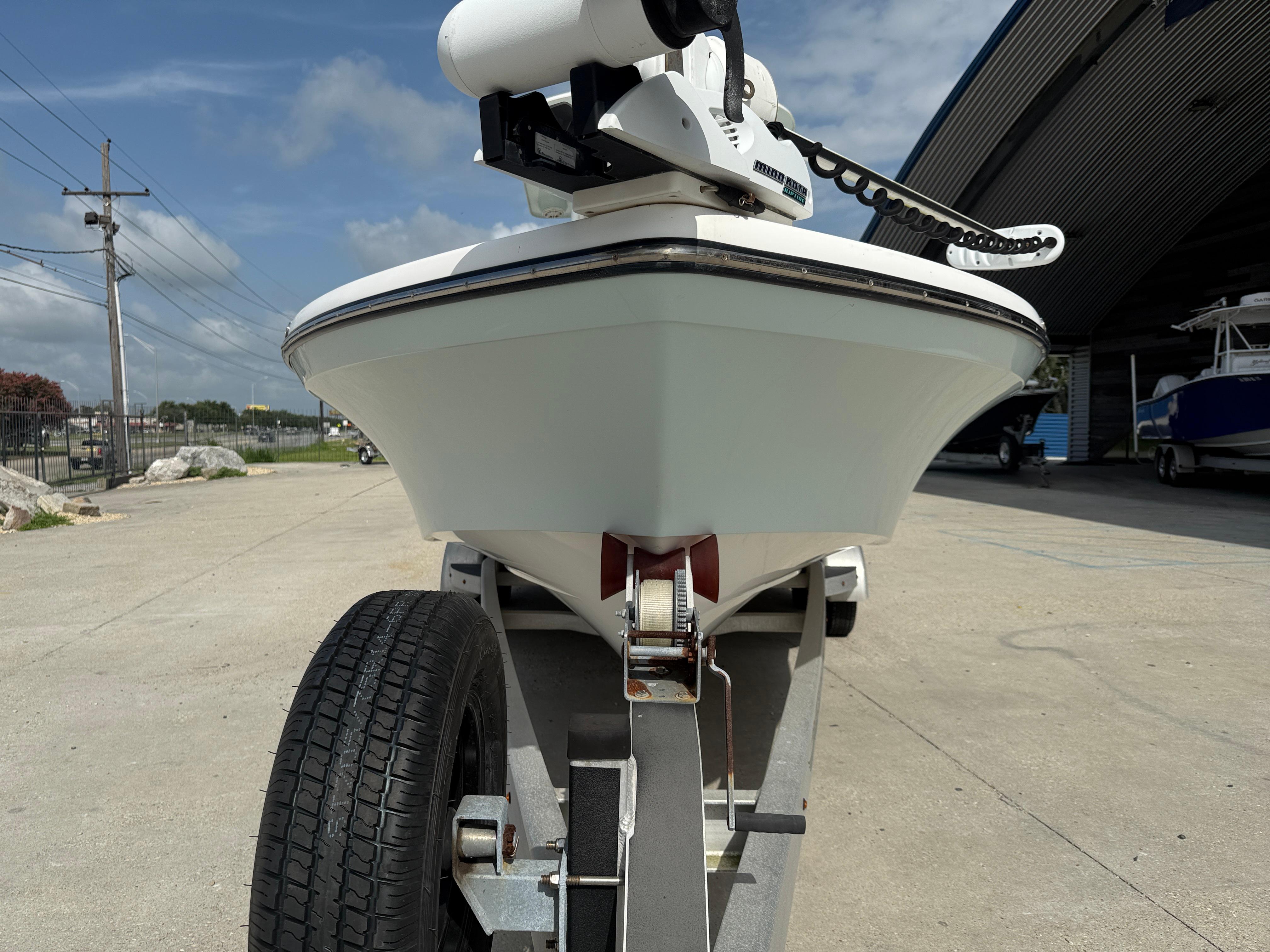 Front view of a 2018 BlackJack 256 boat on a trailer, outdoors under a blue sky.