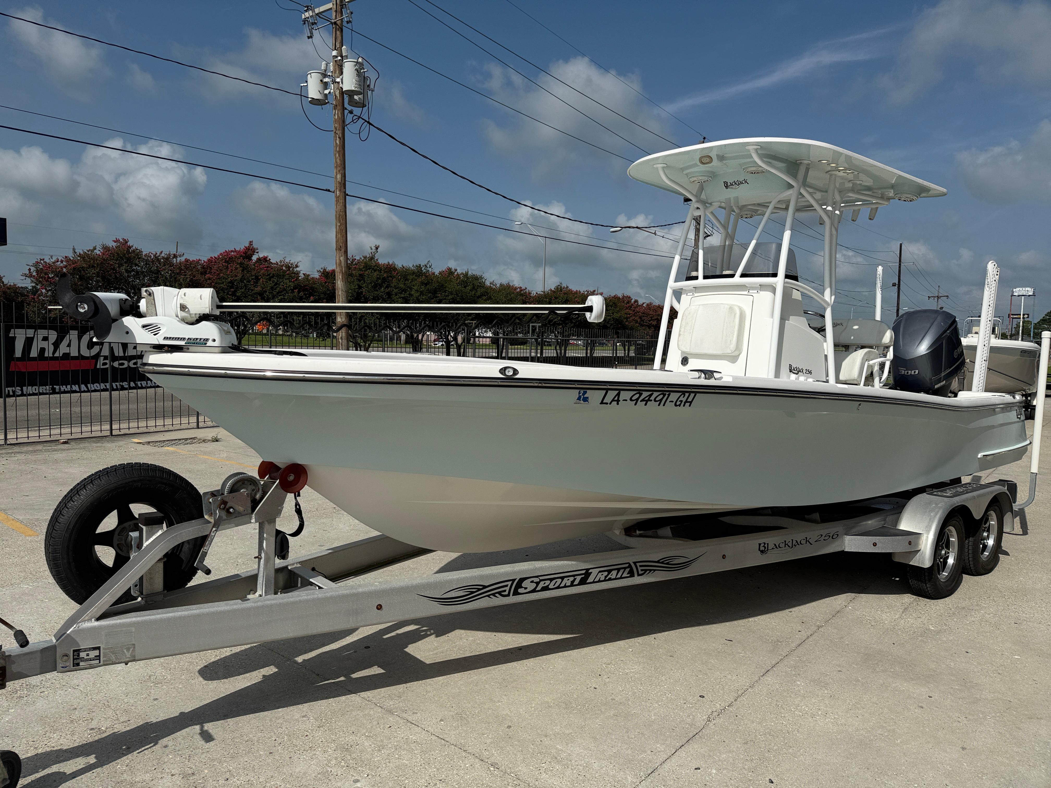 2018 BlackJack 256 boat on trailer, parked outdoors under clear sky.