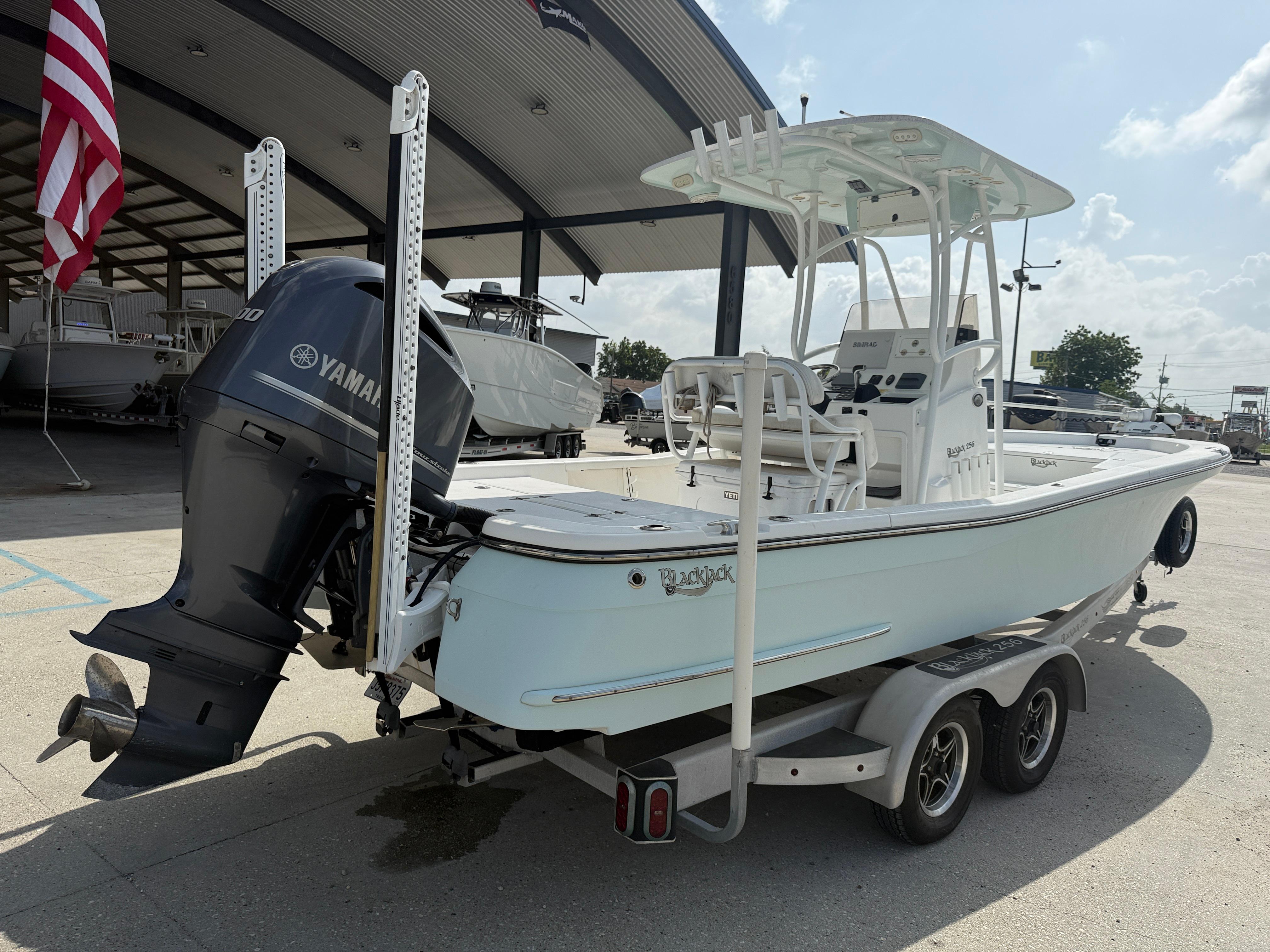 2018 BlackJack 256 boat with Yamaha engine on trailer, parked at a marina.