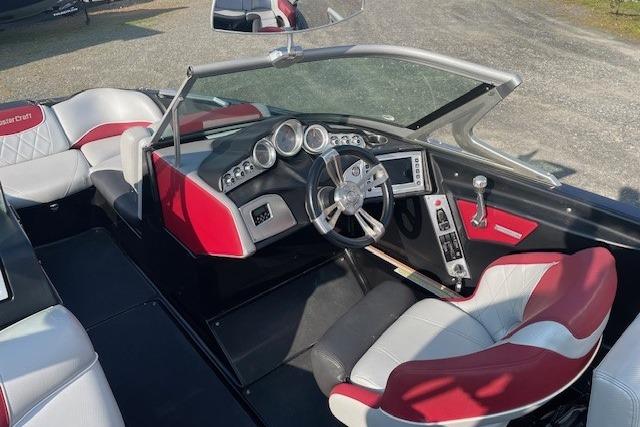 2013 MasterCraft X-25 boat interior with red and white seating, modern dashboard, and steering wheel.