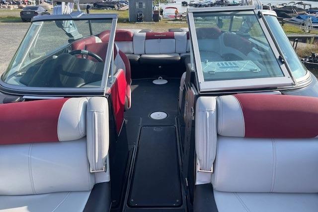 2013 MasterCraft X-25 boat interior with red and white seating, open bow design.