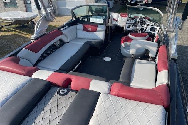 2013 MasterCraft X-25 boat interior with red and gray seating, steering wheel, and dashboard.