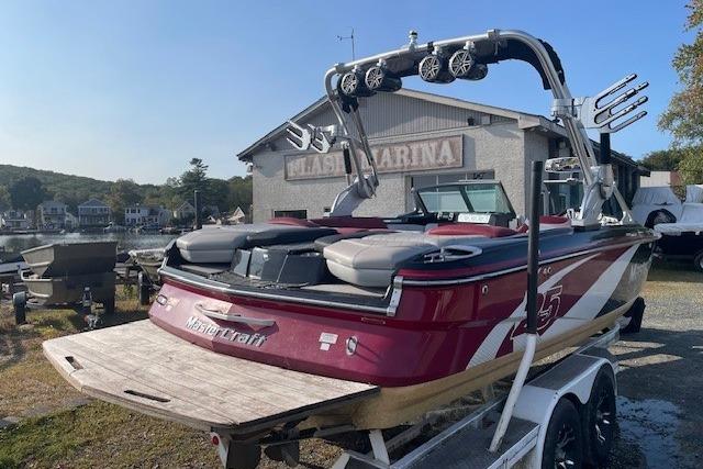 2013 MasterCraft X-25 boat with wakeboard tower, parked at marina.