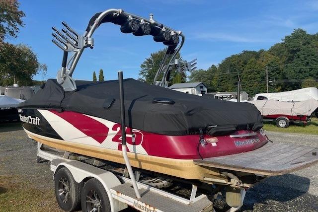 2013 MasterCraft X-25 boat on trailer with cover, parked outdoors.