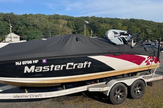 2013 MasterCraft X-25 boat on trailer, covered, parked outdoors.
