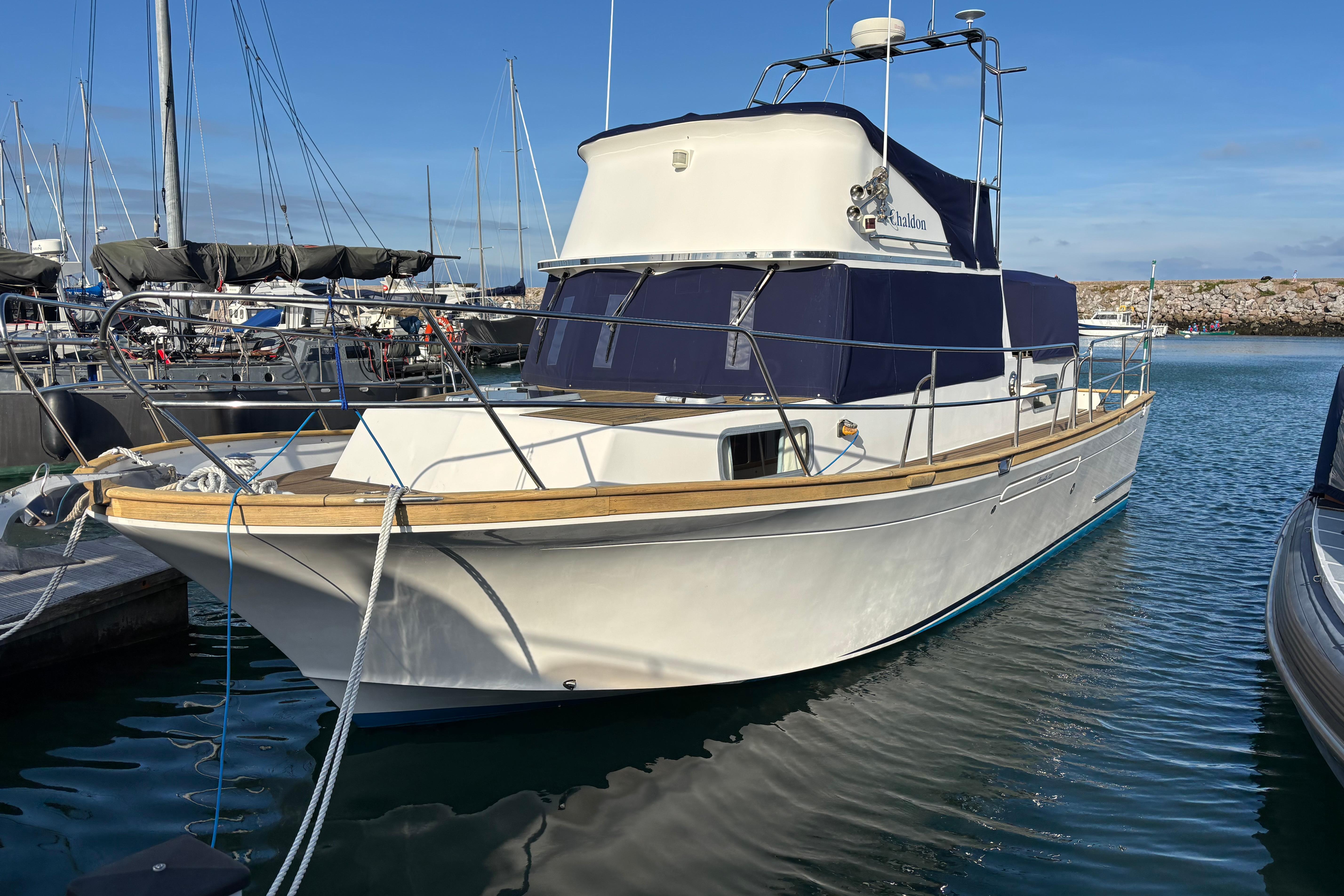 2001 Corvette 320 boat docked in marina, featuring sleek design and blue canopy.