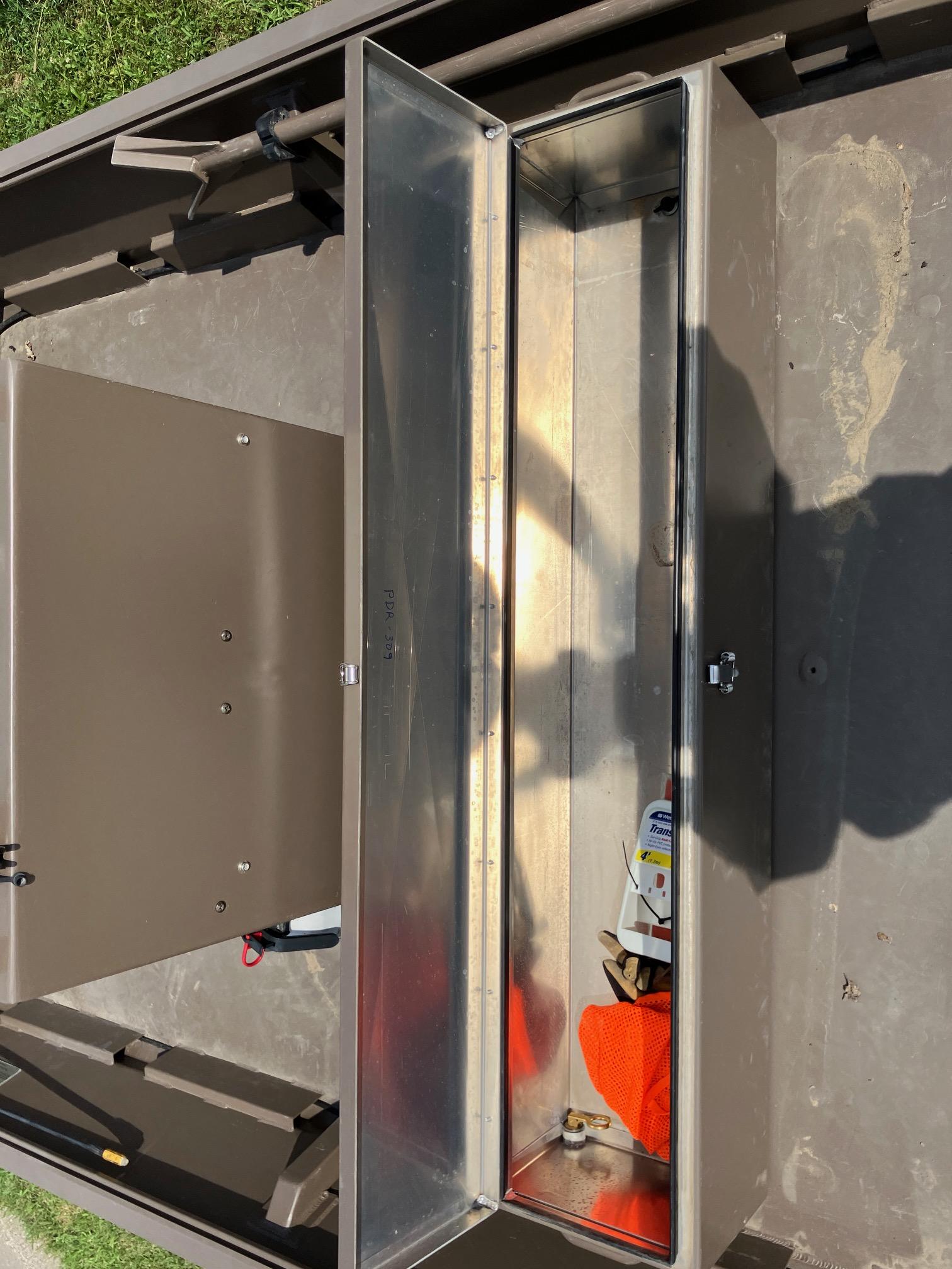 Open storage compartment in a 2017 Pro-Drive SBX Series 18' boat, showing interior contents.