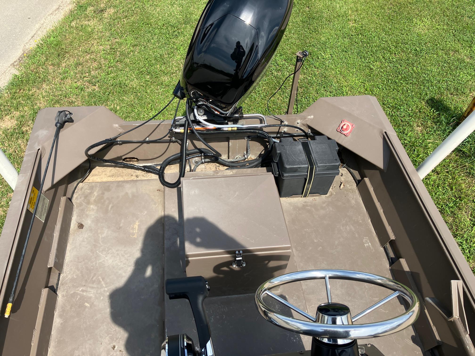 2017 Pro-Drive SBX Series 18' boat interior with steering wheel and motor, on grass.