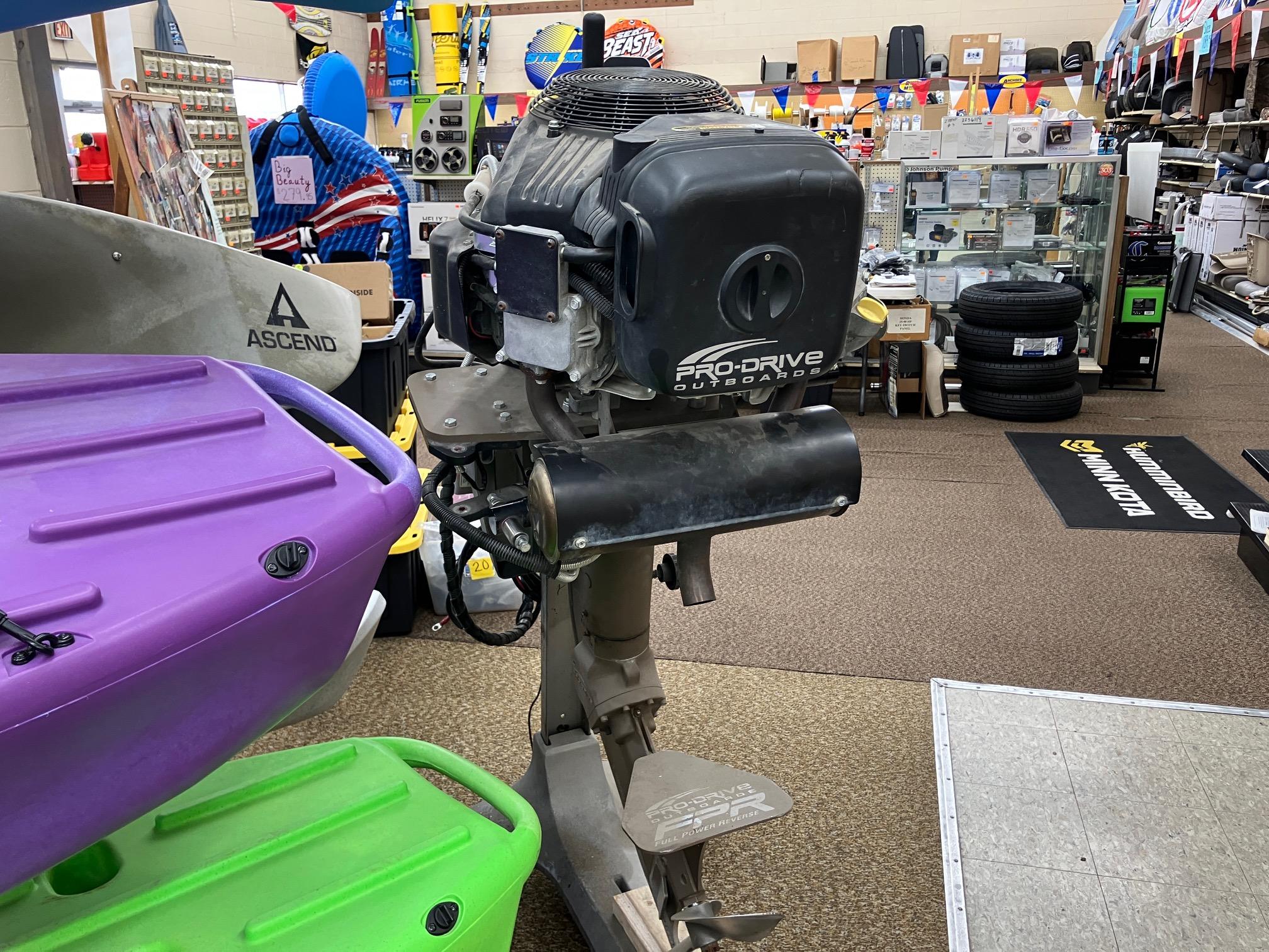2017 Pro-Drive SBX Series 18' outboard motor displayed in a store with colorful kayaks.