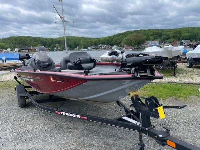 2023 Tracker Pro Team 175 TXW boat on trailer by a lake under cloudy skies.