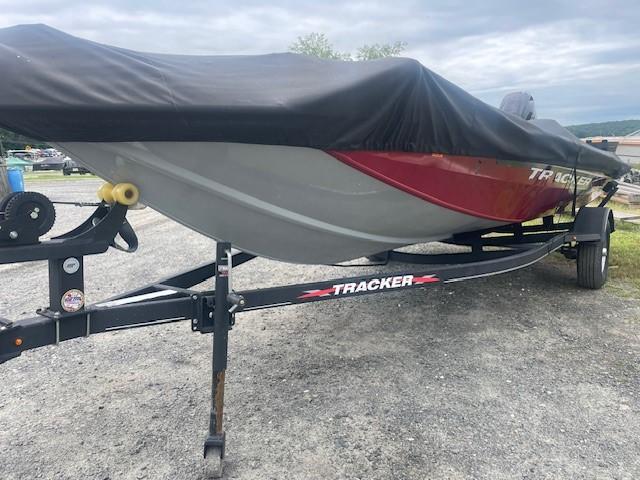 2023 Tracker Pro Team 175 TXW boat on trailer, covered, parked on gravel.