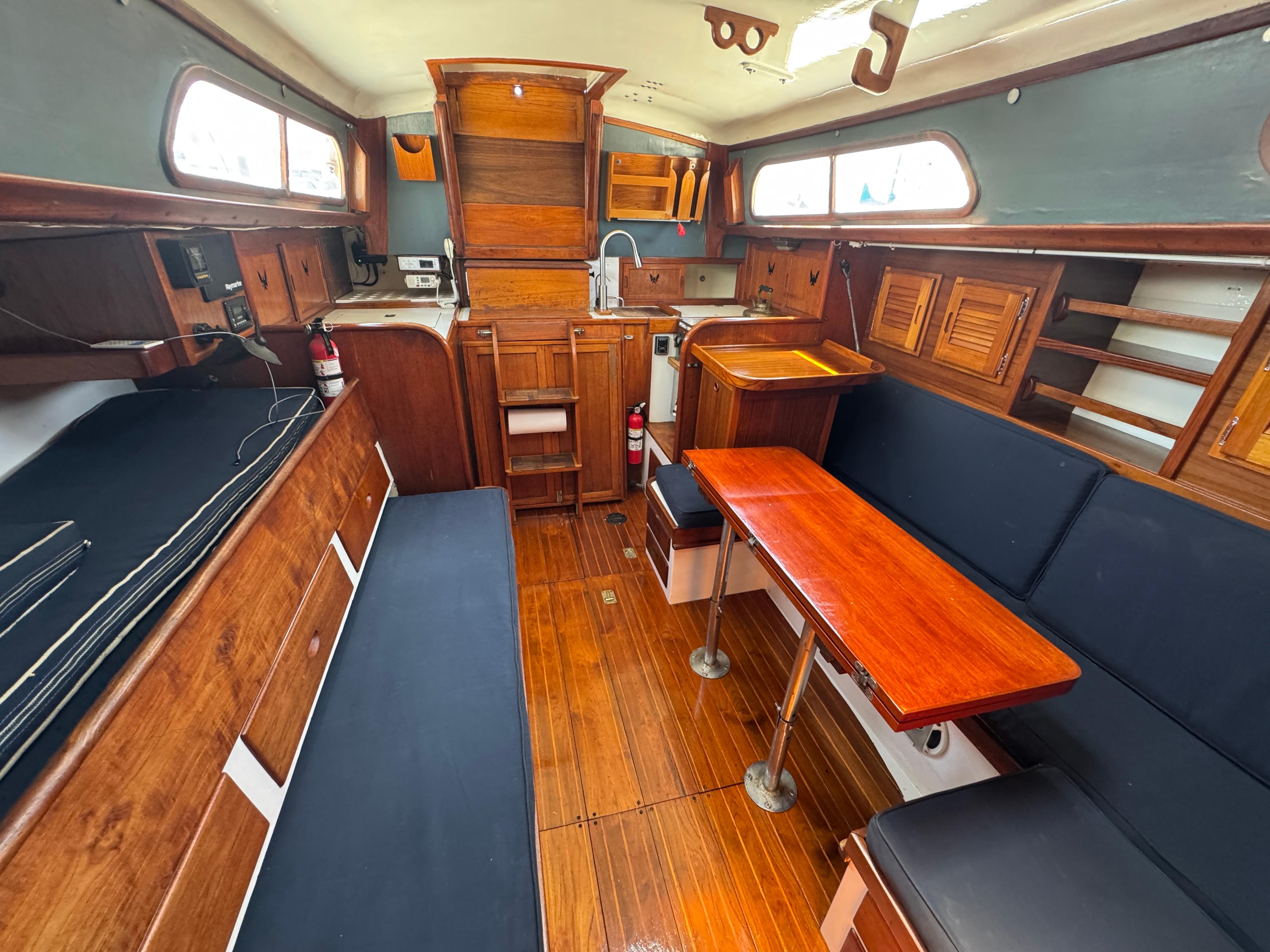 Interior of 1970 Cheoy Lee Luders 36 sailboat with wooden furnishings and seating.