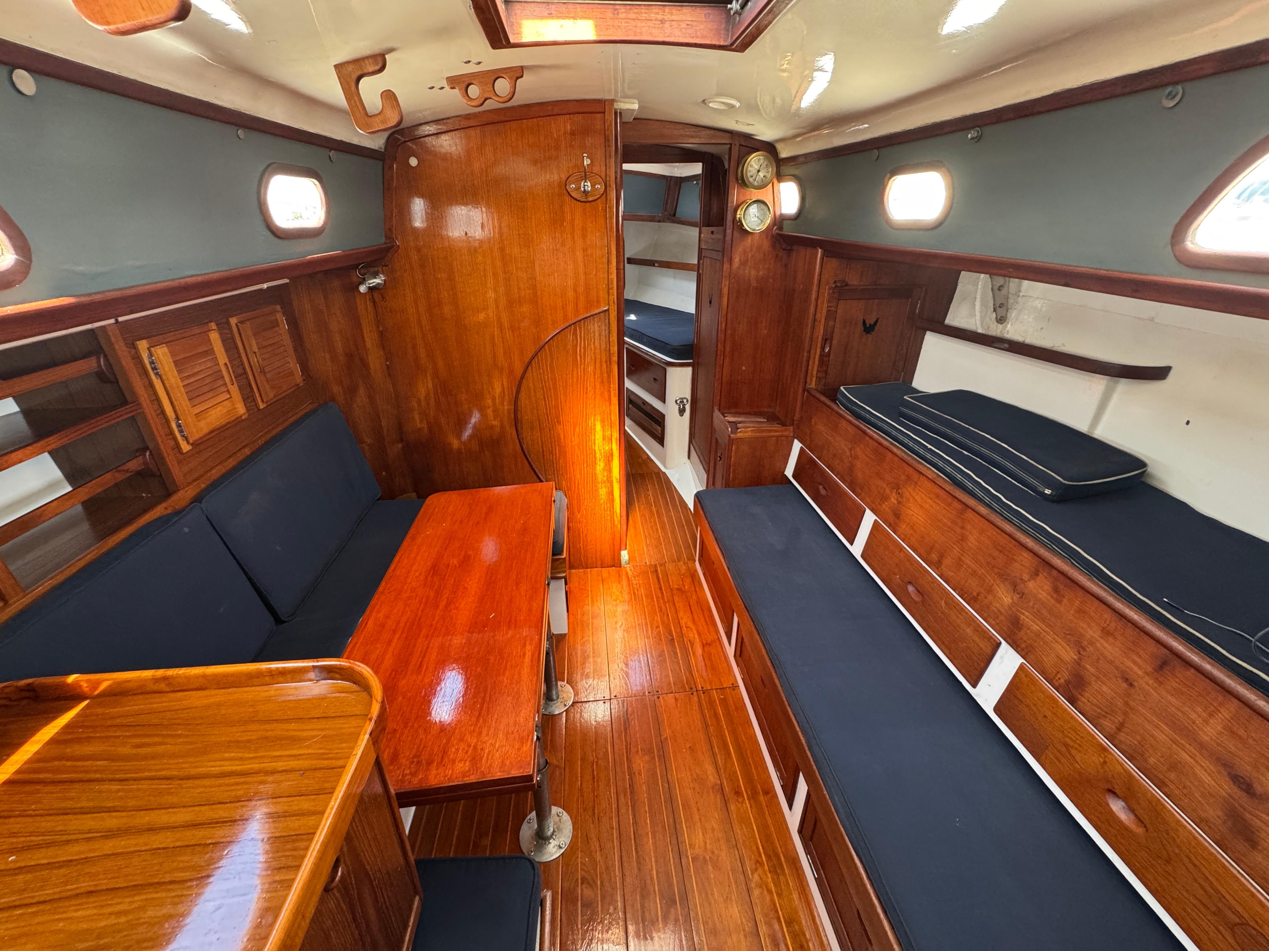 1970 Cheoy Lee Luders 36 yacht interior with wooden finish and blue seating.