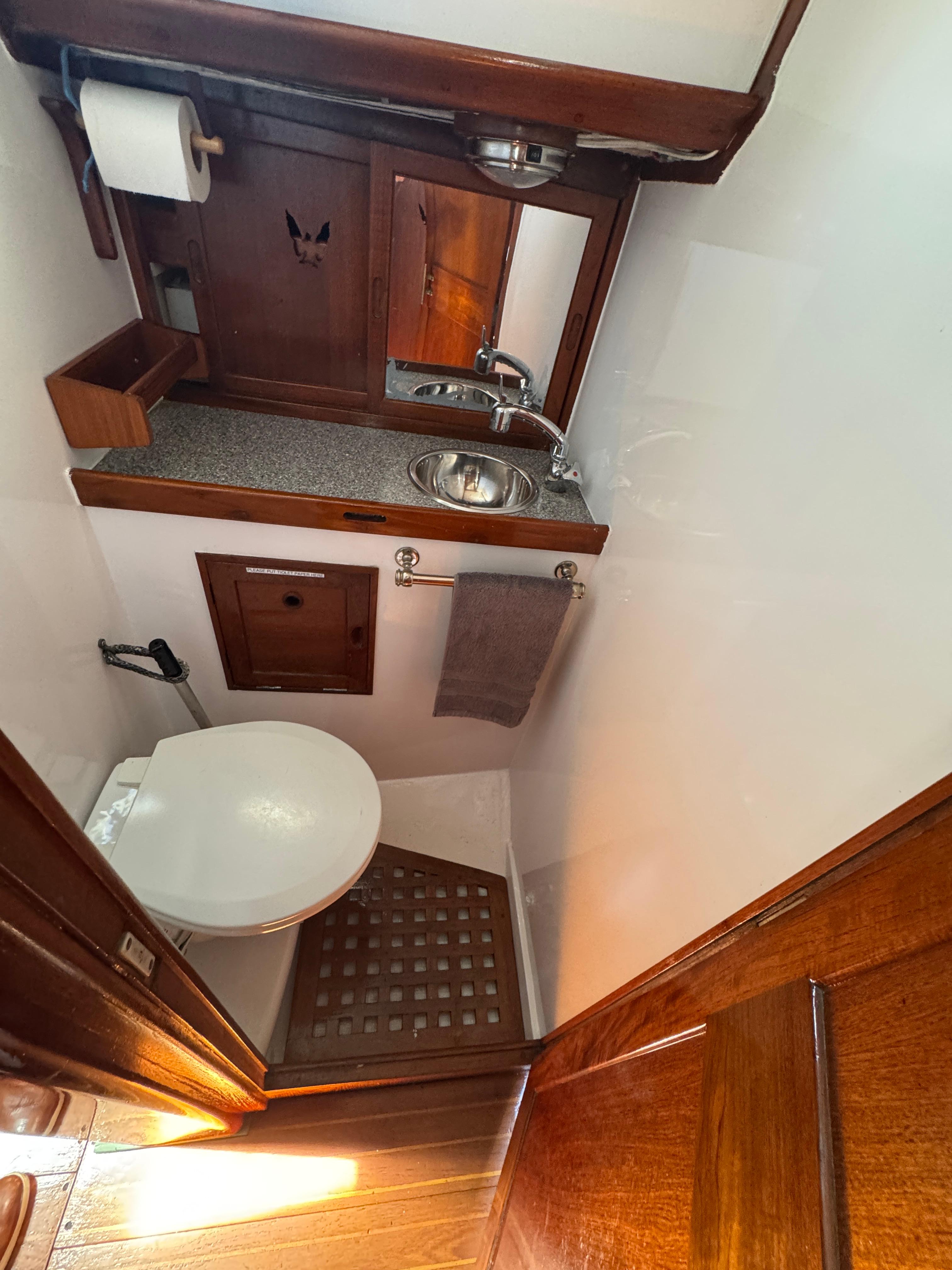 1970 Cheoy Lee Luders 36 yacht bathroom with wooden accents and compact design.