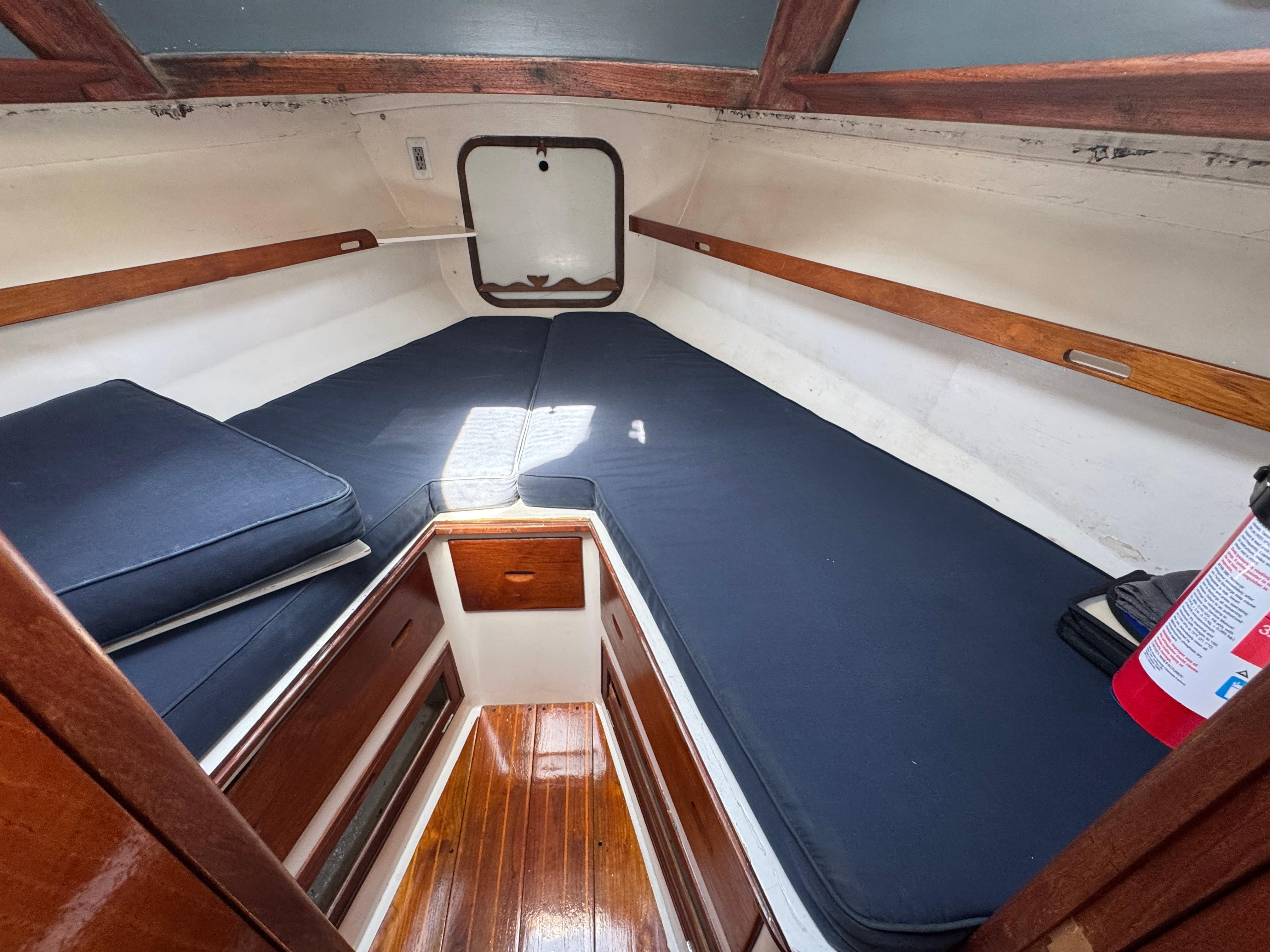 1970 Cheoy Lee Luders 36 cabin interior with wooden finish and blue cushions.