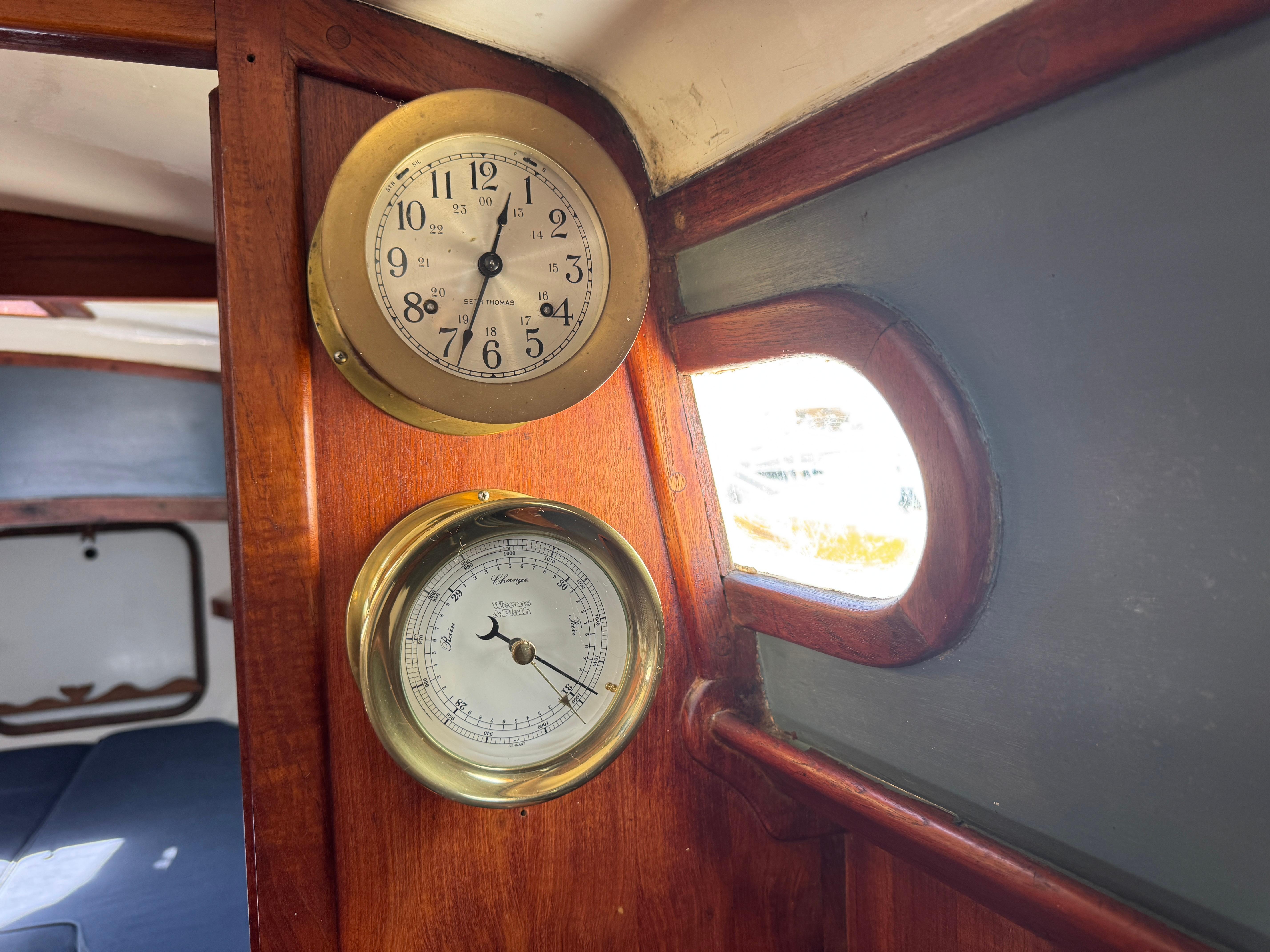 Interior of 1970 Cheoy Lee Luders 36 yacht with clock and barometer on wooden panel.