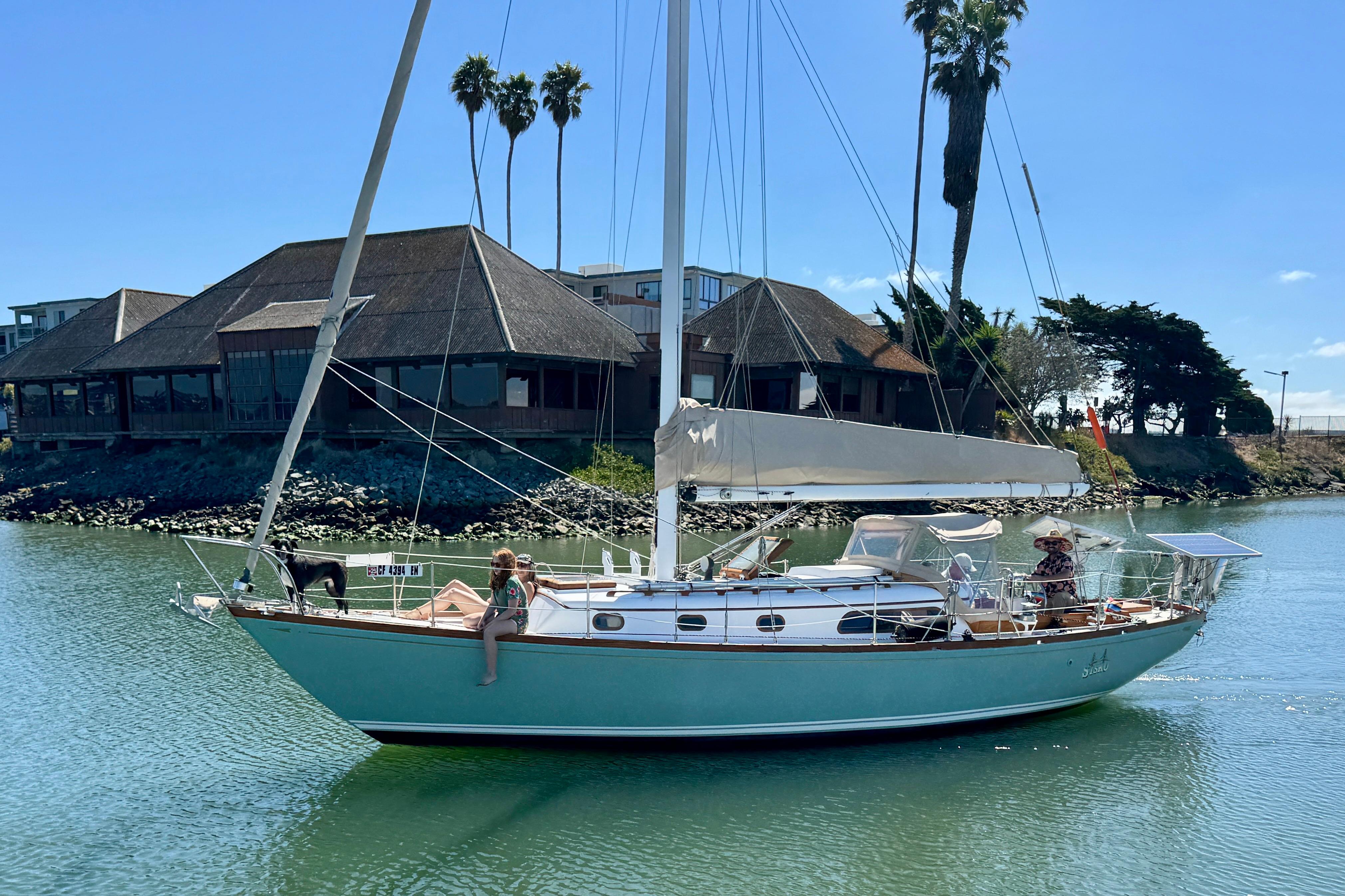 1970 Cheoy Lee Luders 36 sailboat on calm water, with people relaxing onboard.