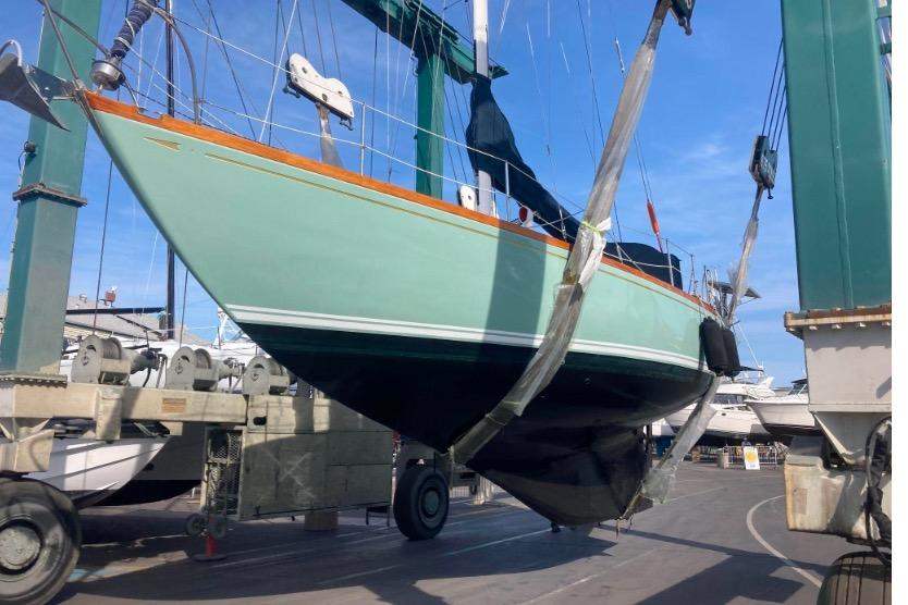 1970 Cheoy Lee Luders 36 sailboat in dry dock, suspended by a crane.