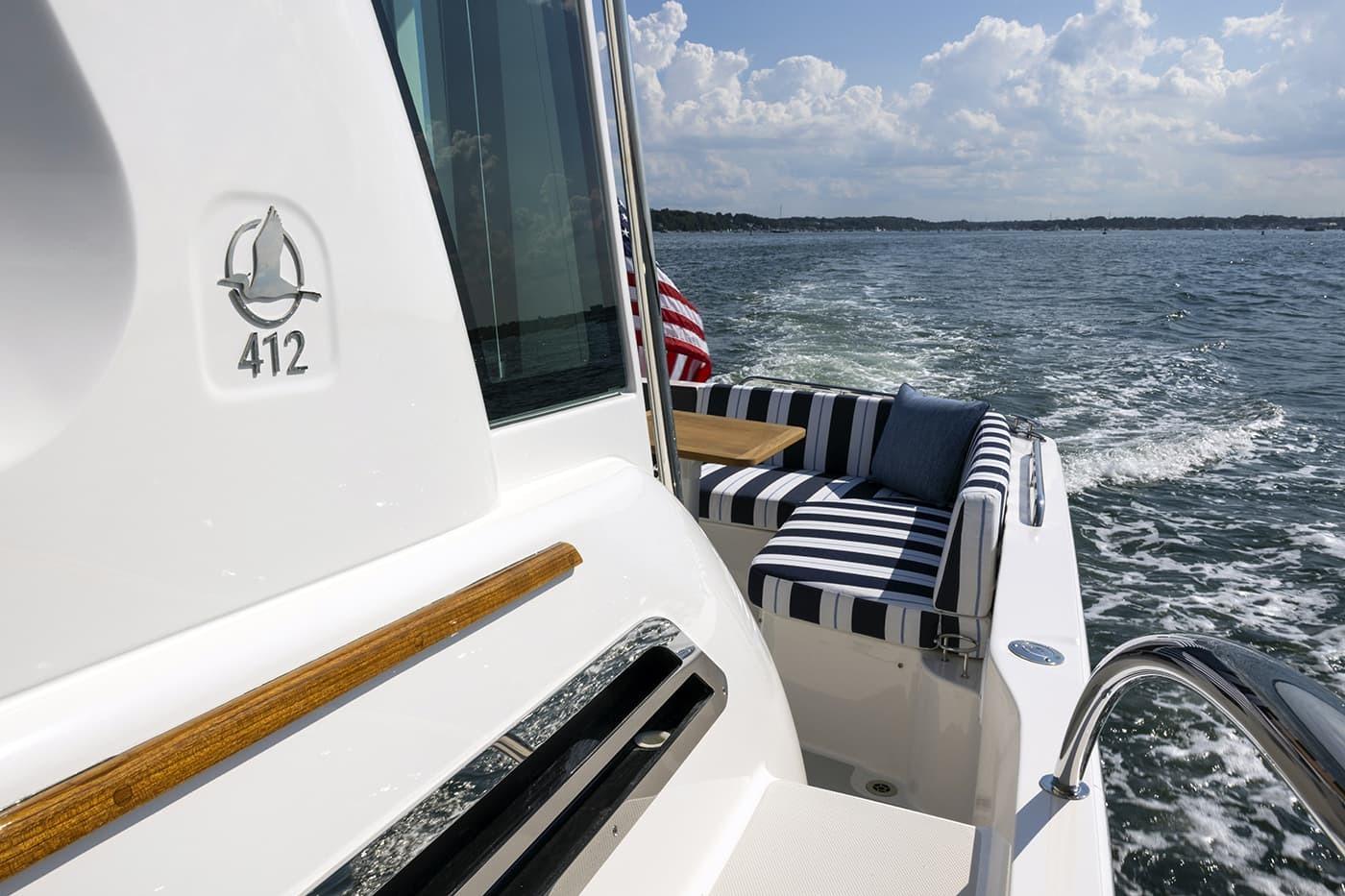 2026 Back Cove 412 yacht with striped seating, cruising on a sunny day.