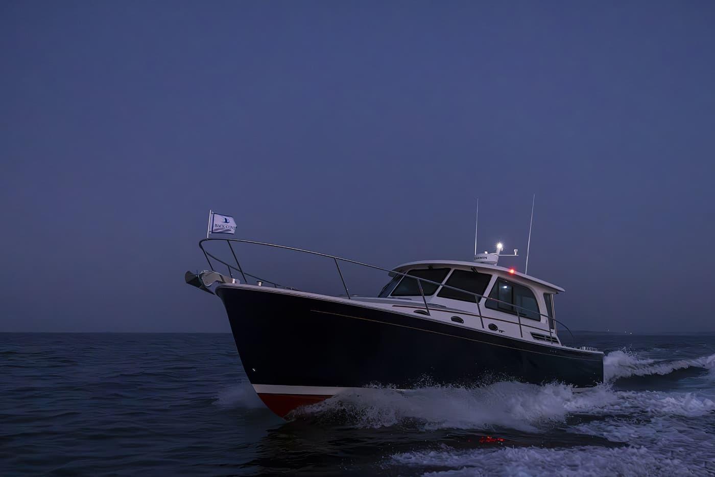 2026 Back Cove 412 yacht cruising at dusk on open water.