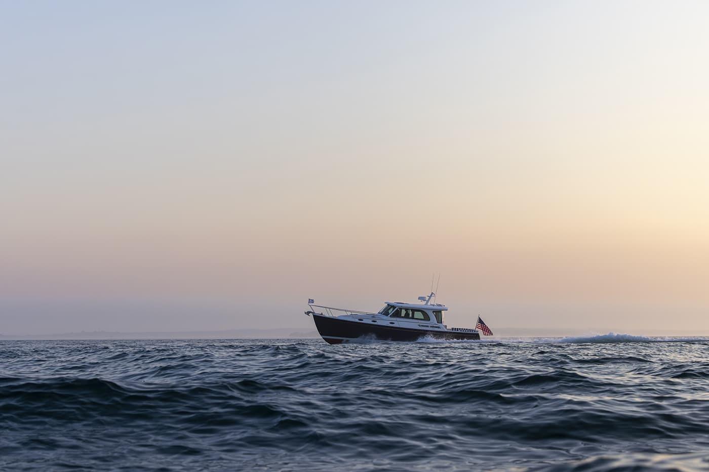 2026 Back Cove 412 cruising on calm ocean at sunset.