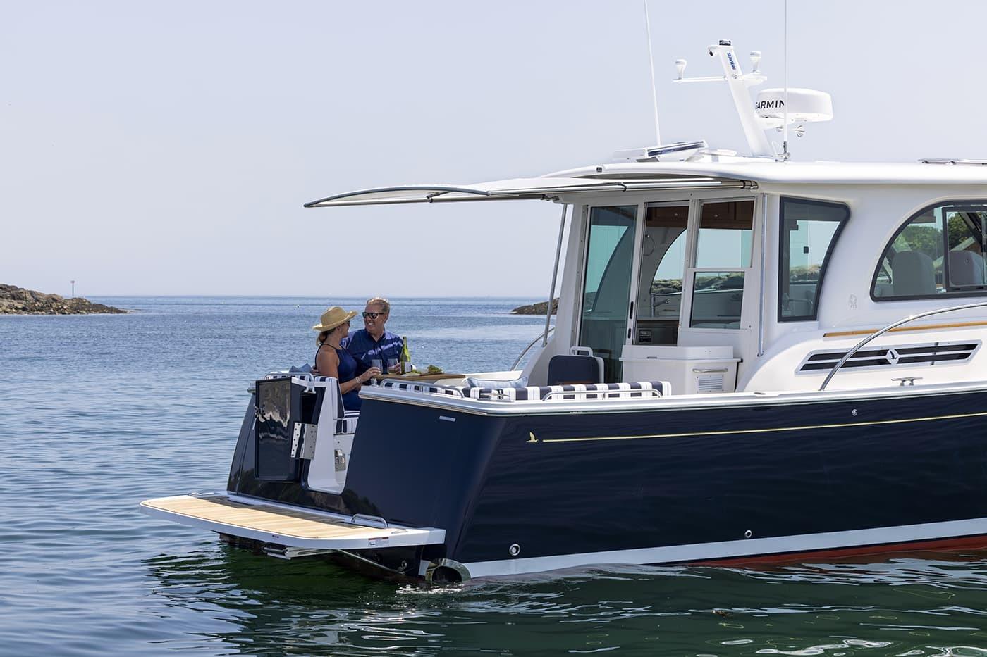 2026 Back Cove 412 yacht on water, two people enjoying the deck.