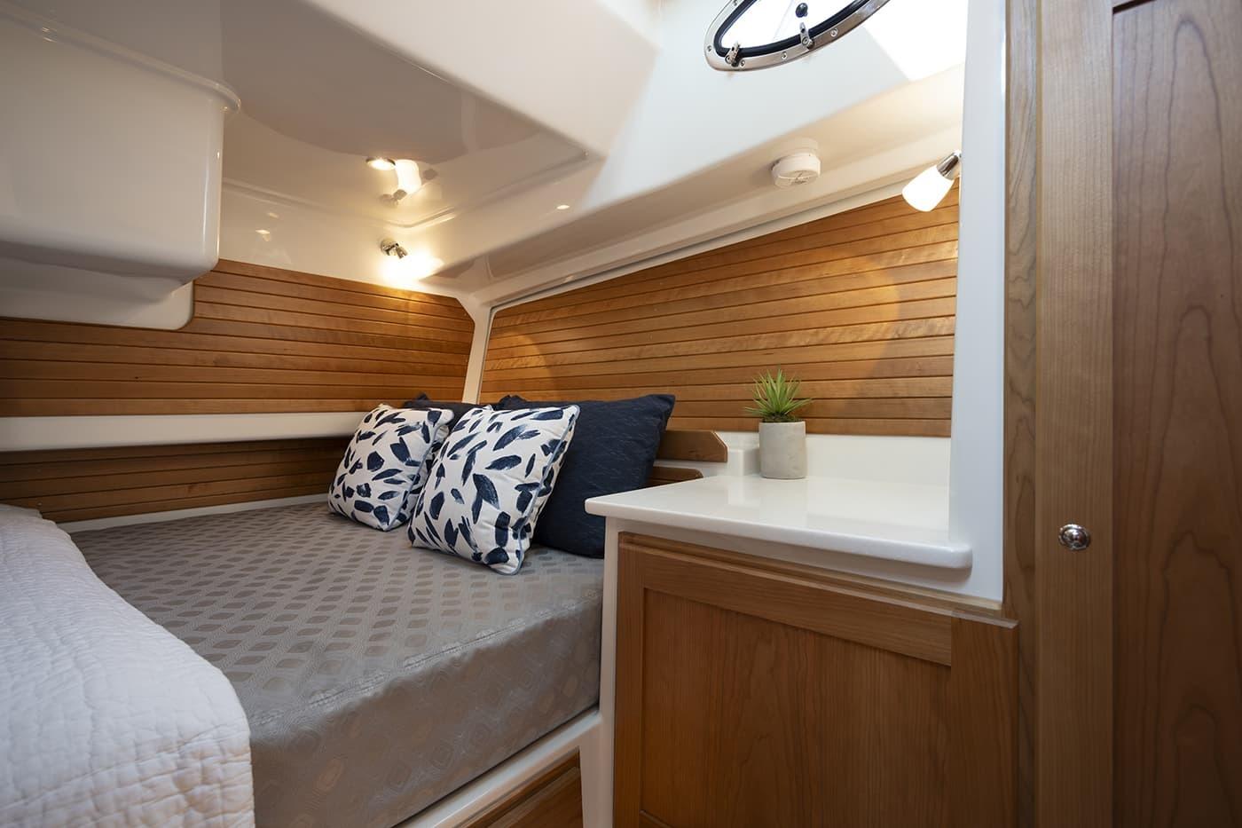 Luxurious cabin interior of 2026 Back Cove 412 yacht with cozy bedding and wooden accents.