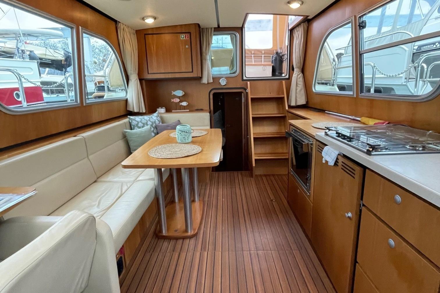 Interior of 2012 Linssen 36.9 yacht with wood finish and cozy seating area.