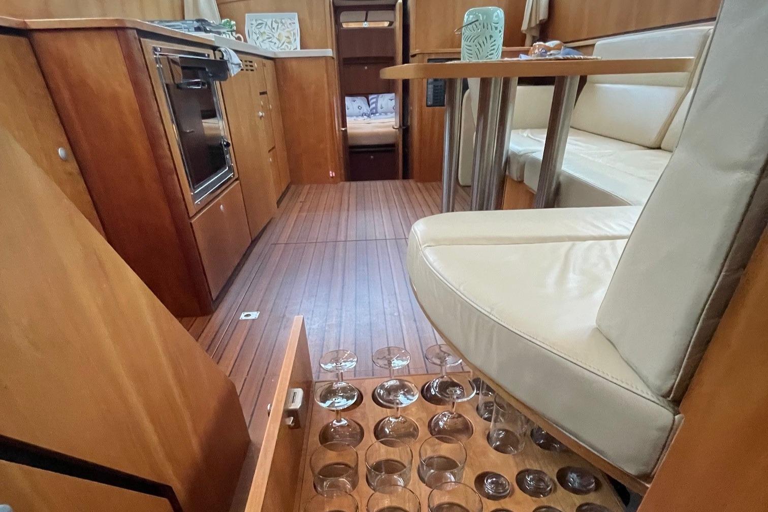 Interior of 2012 Linssen 36.9 yacht with wooden flooring and built-in glass storage.