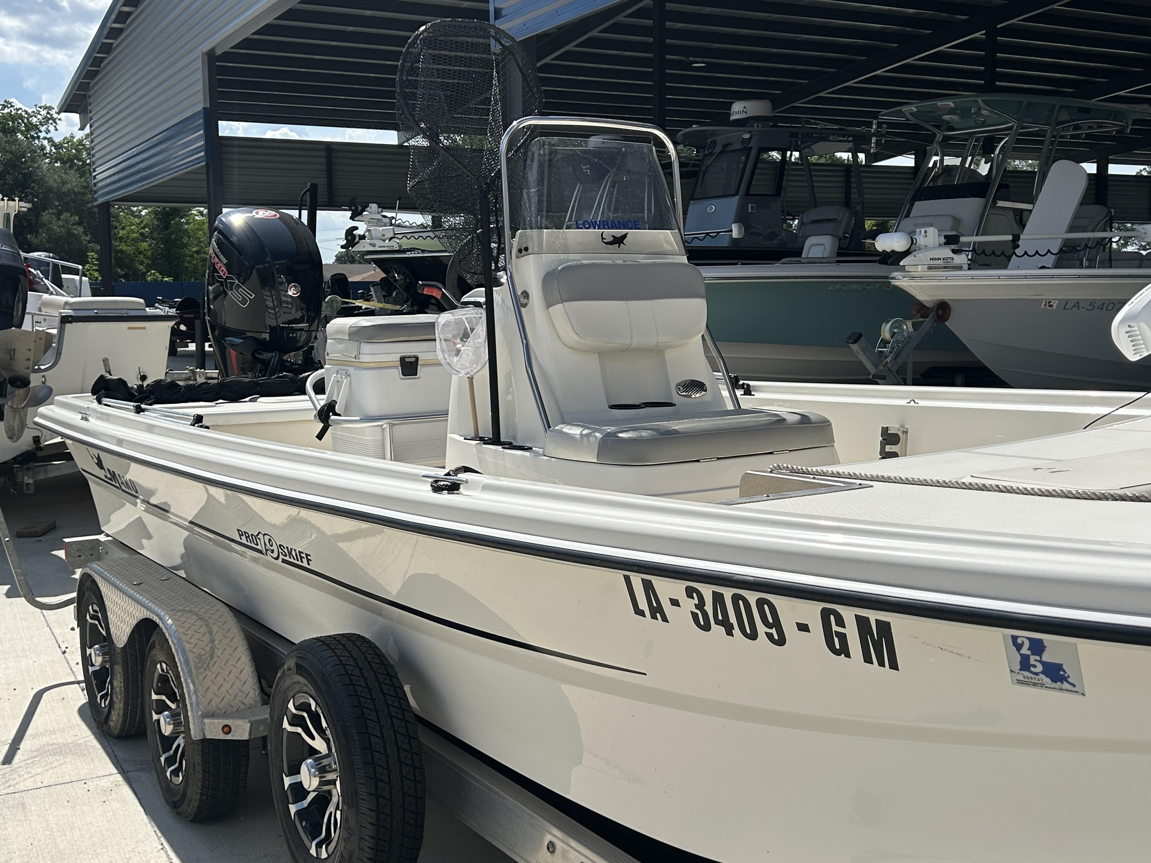 2021 Mako Pro Skiff 19 CC boat on trailer, parked under a metal canopy.