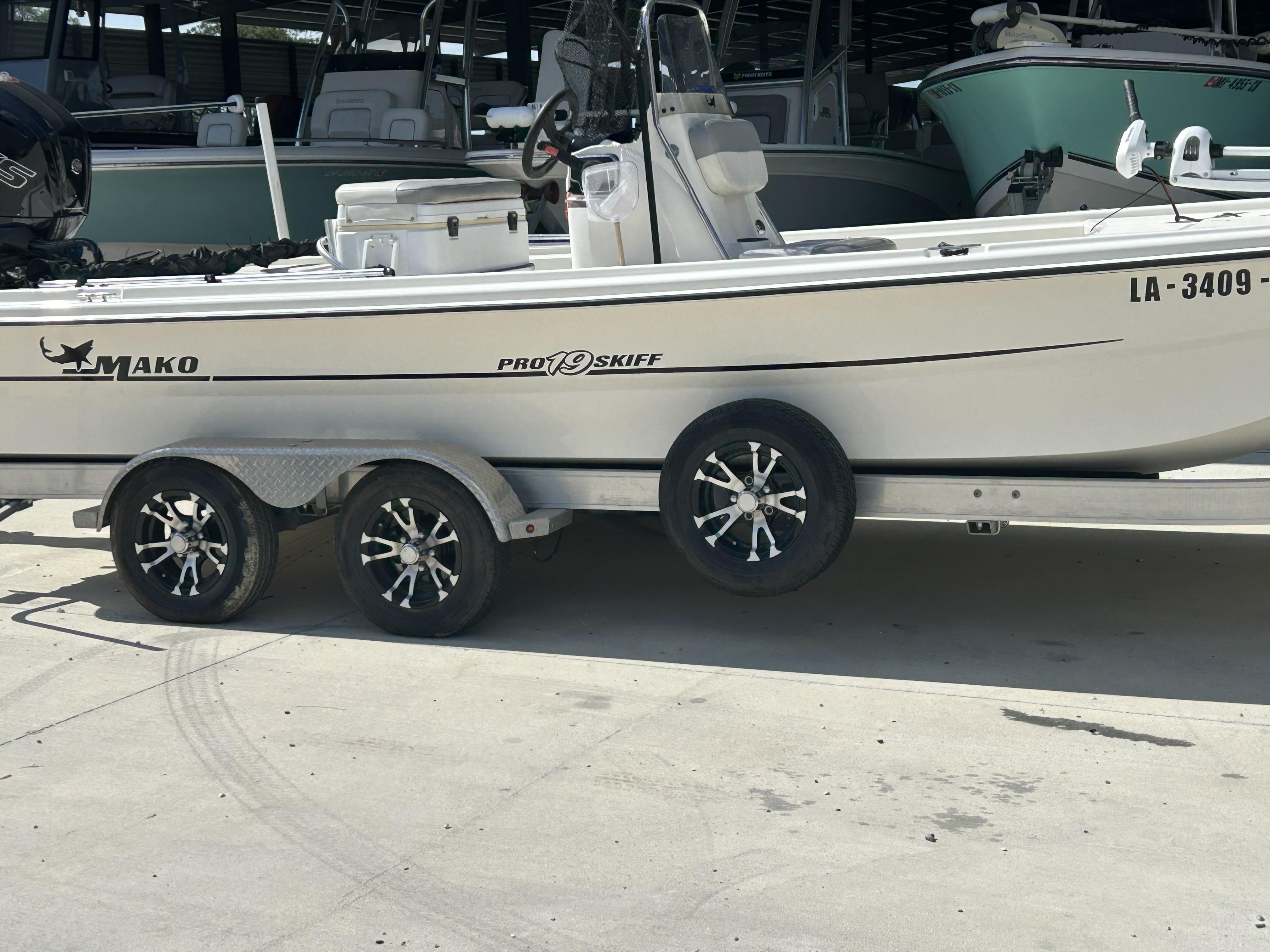 2021 Mako Pro Skiff 19 CC boat on trailer in marina setting.