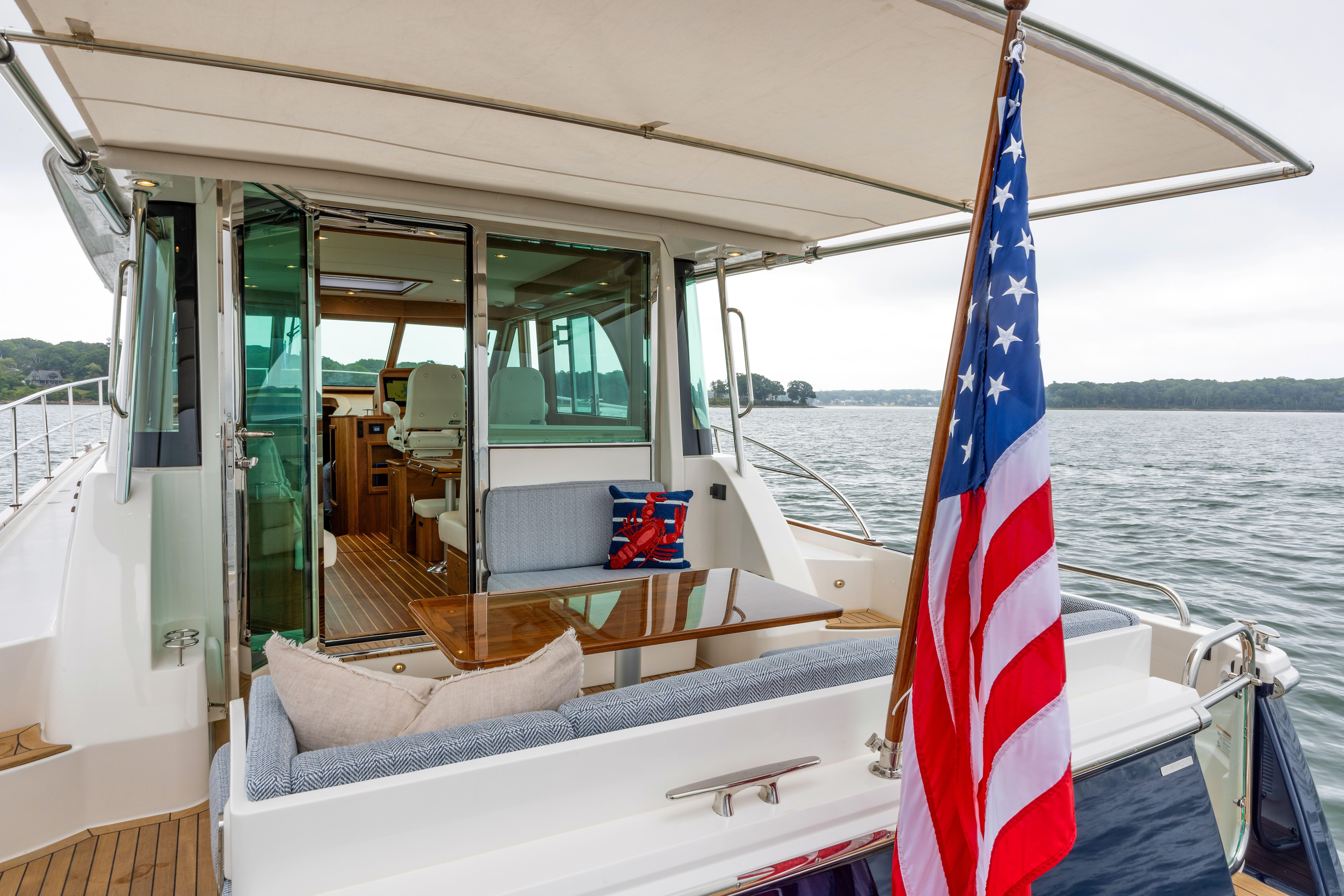 2026 Sabre 45 Salon Express yacht with American flag, elegant interior, and scenic water view.
